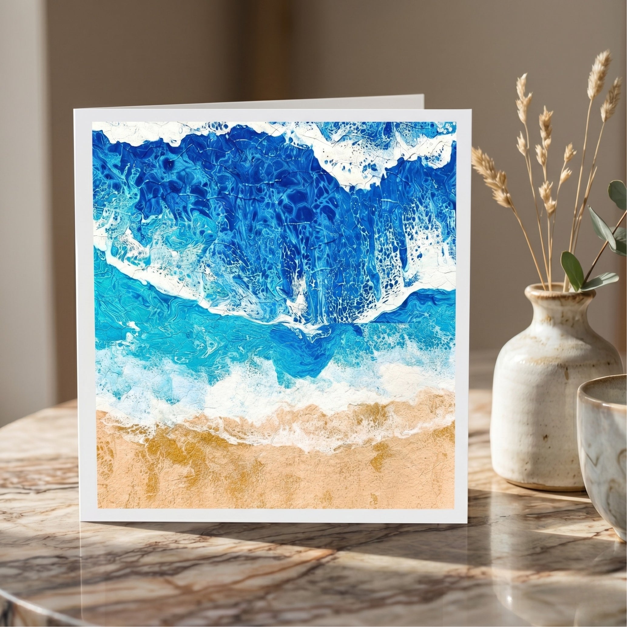 Greeting card with ocean wave design on a marble surface with decorative elements.