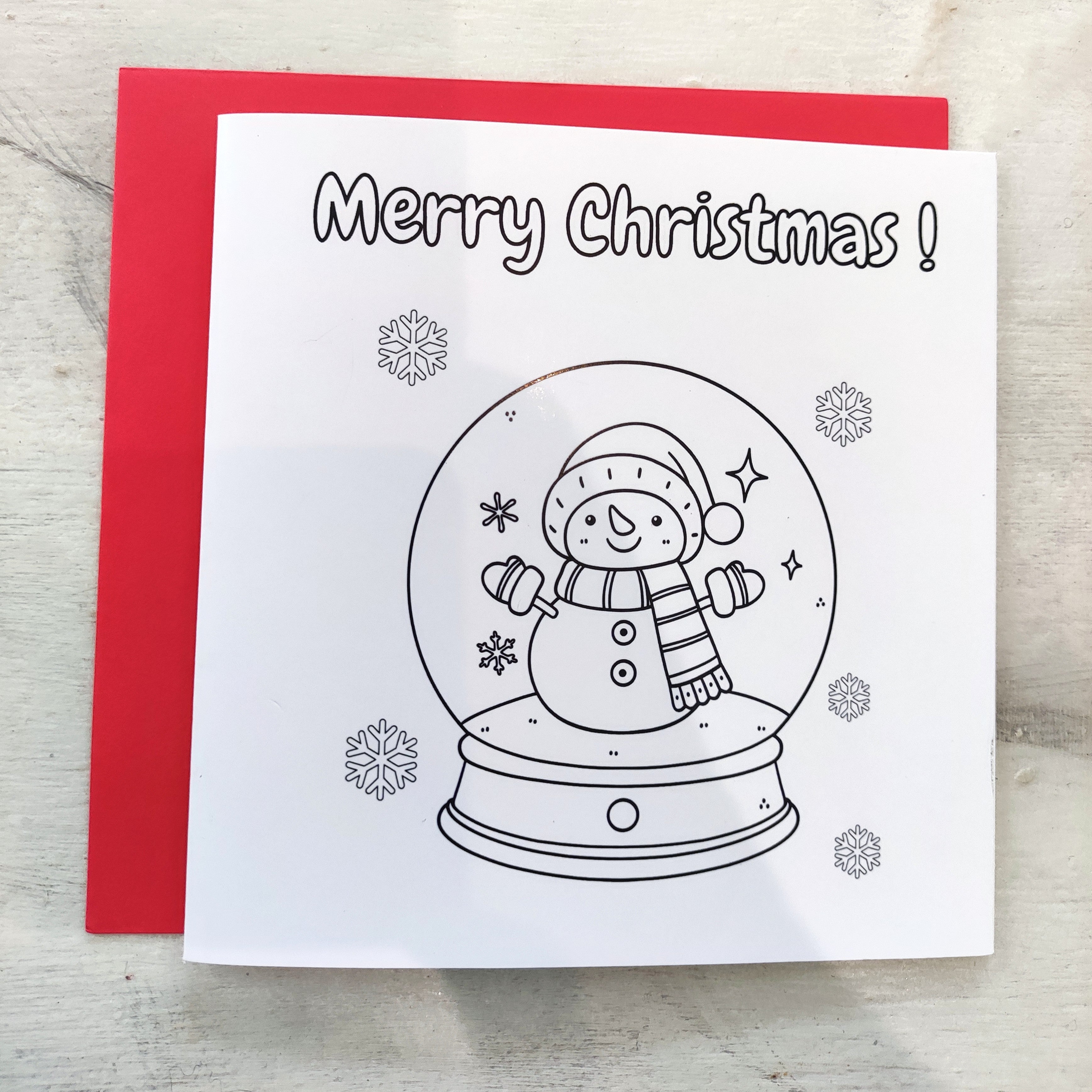 Christmas card with snowman in a globe and 'Merry Christmas!' text on a red envelope.
