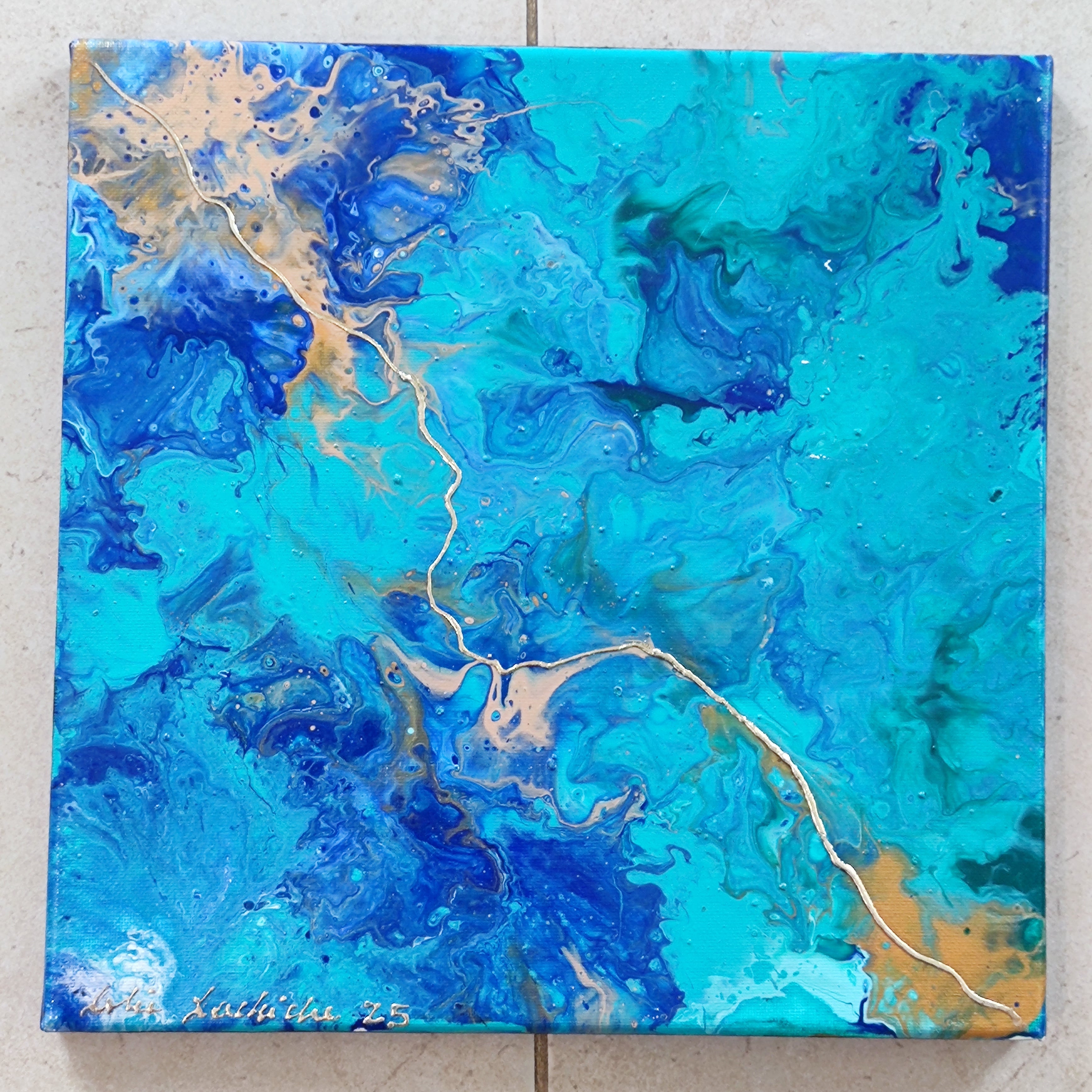 Abstract painting with blue and gold colors on a textured surface
