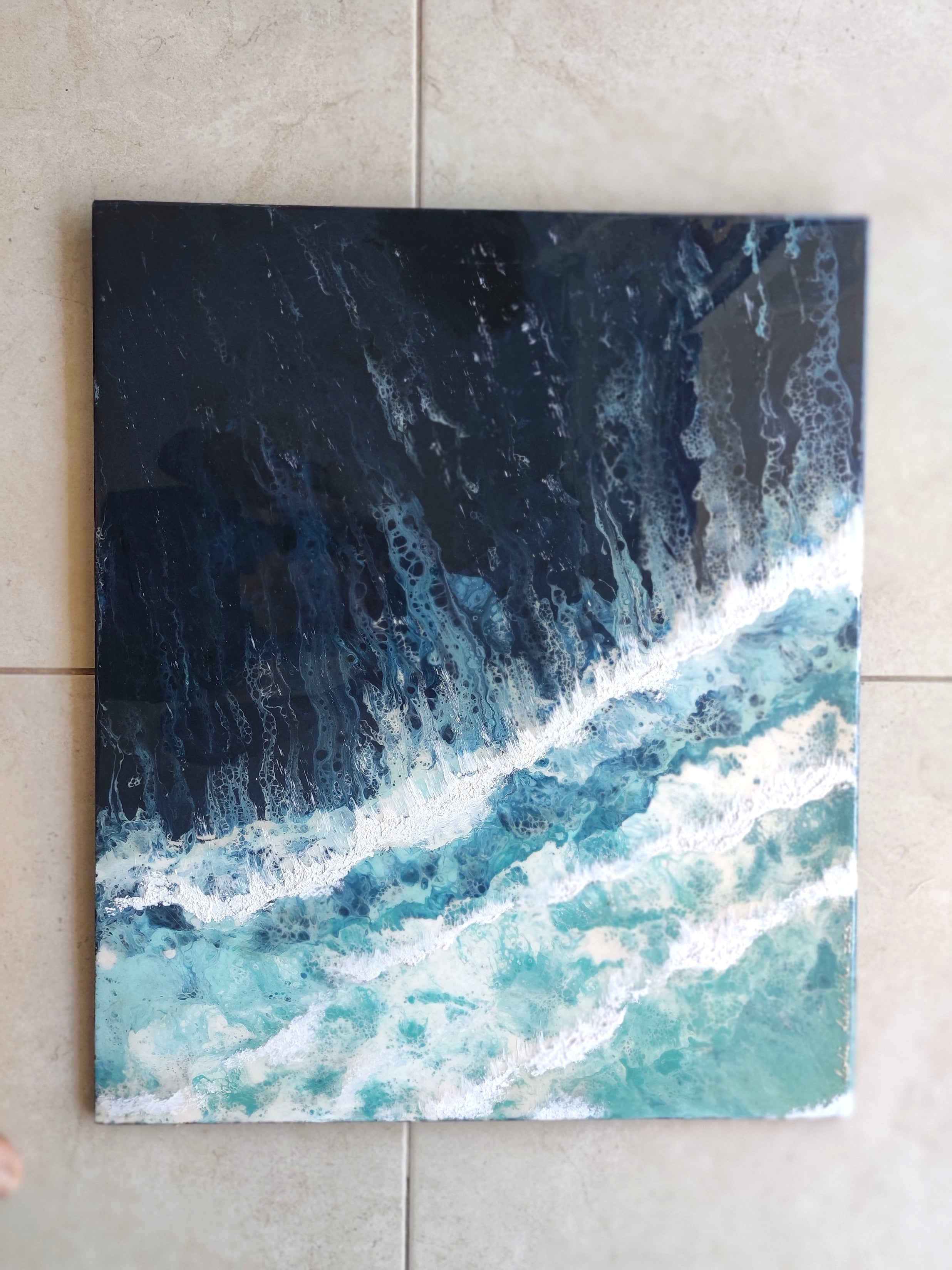 Abstract painting of ocean waves on a tiled wall