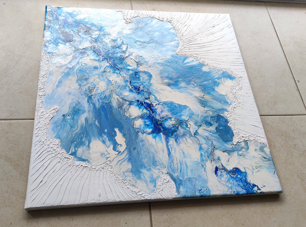 Abstract art piece with blue and white colors on a textured surface