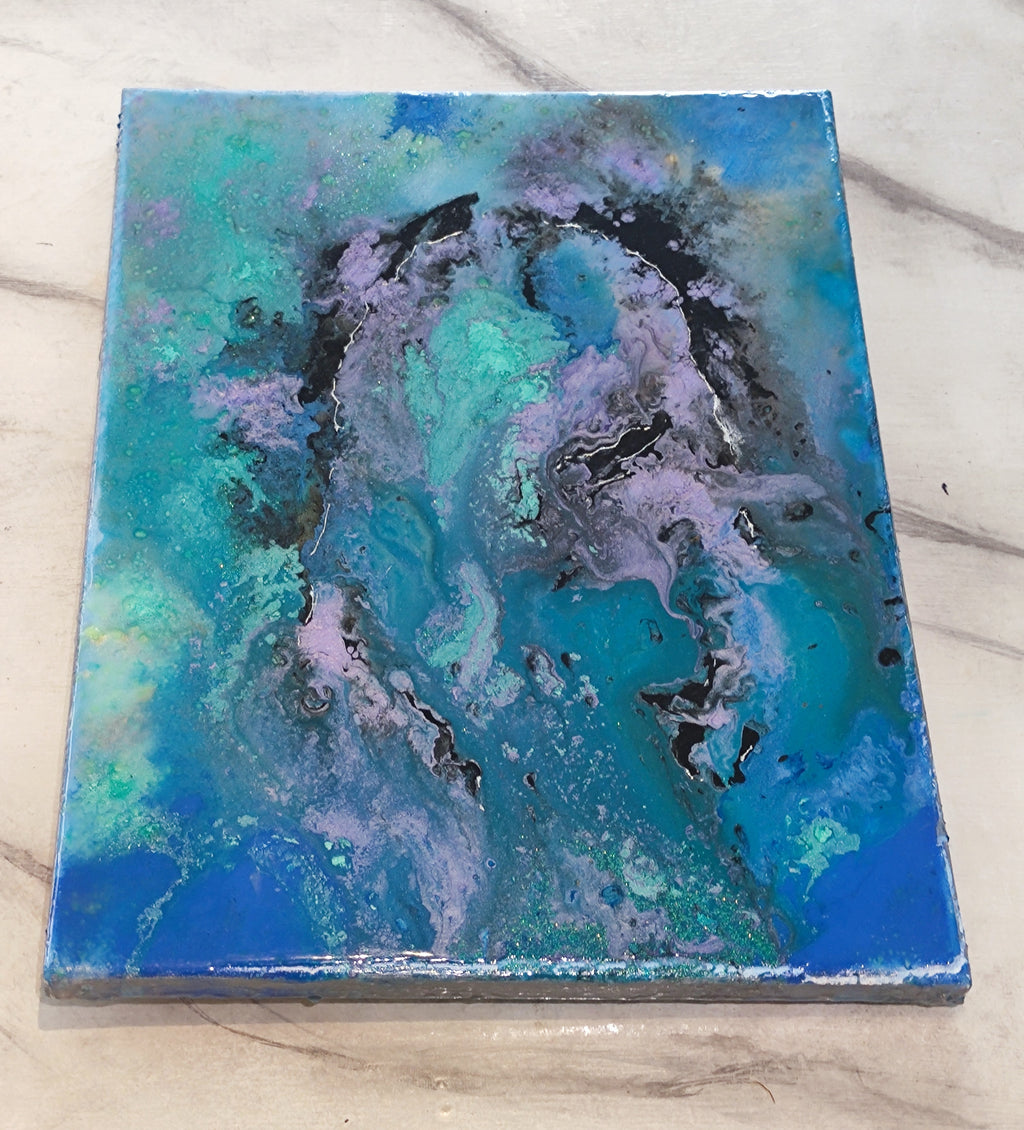 Abstract art piece with blue, green, and black colors on a marble surface
