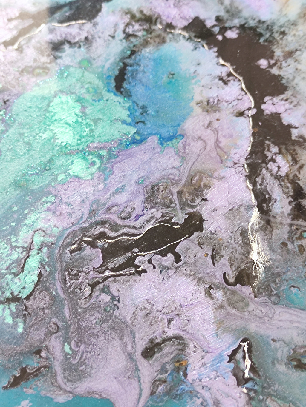 Abstract art with swirling colors of blue, green, and black on a textured surface.