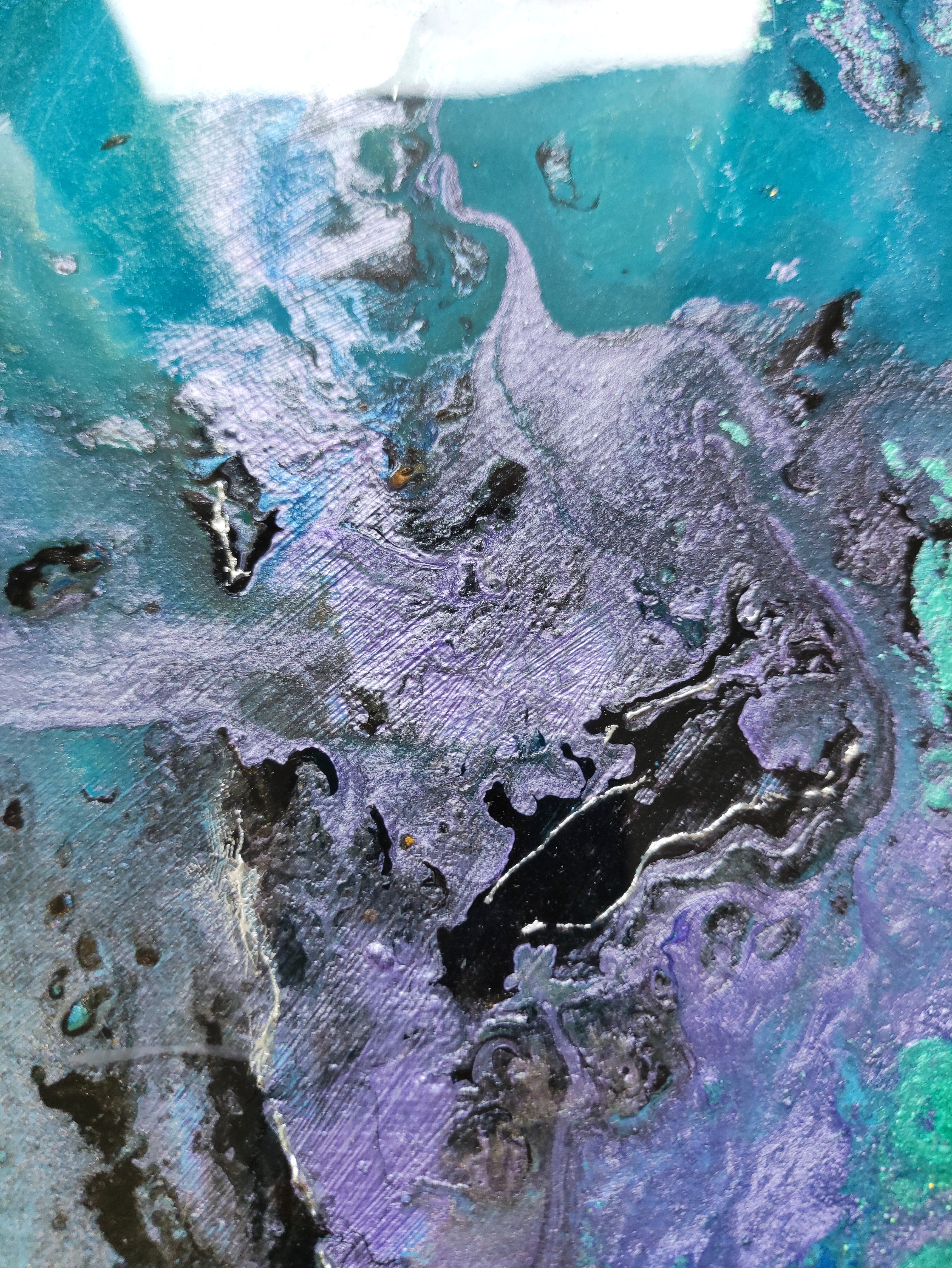 Close-up of a textured surface with green, purple, and brown colors