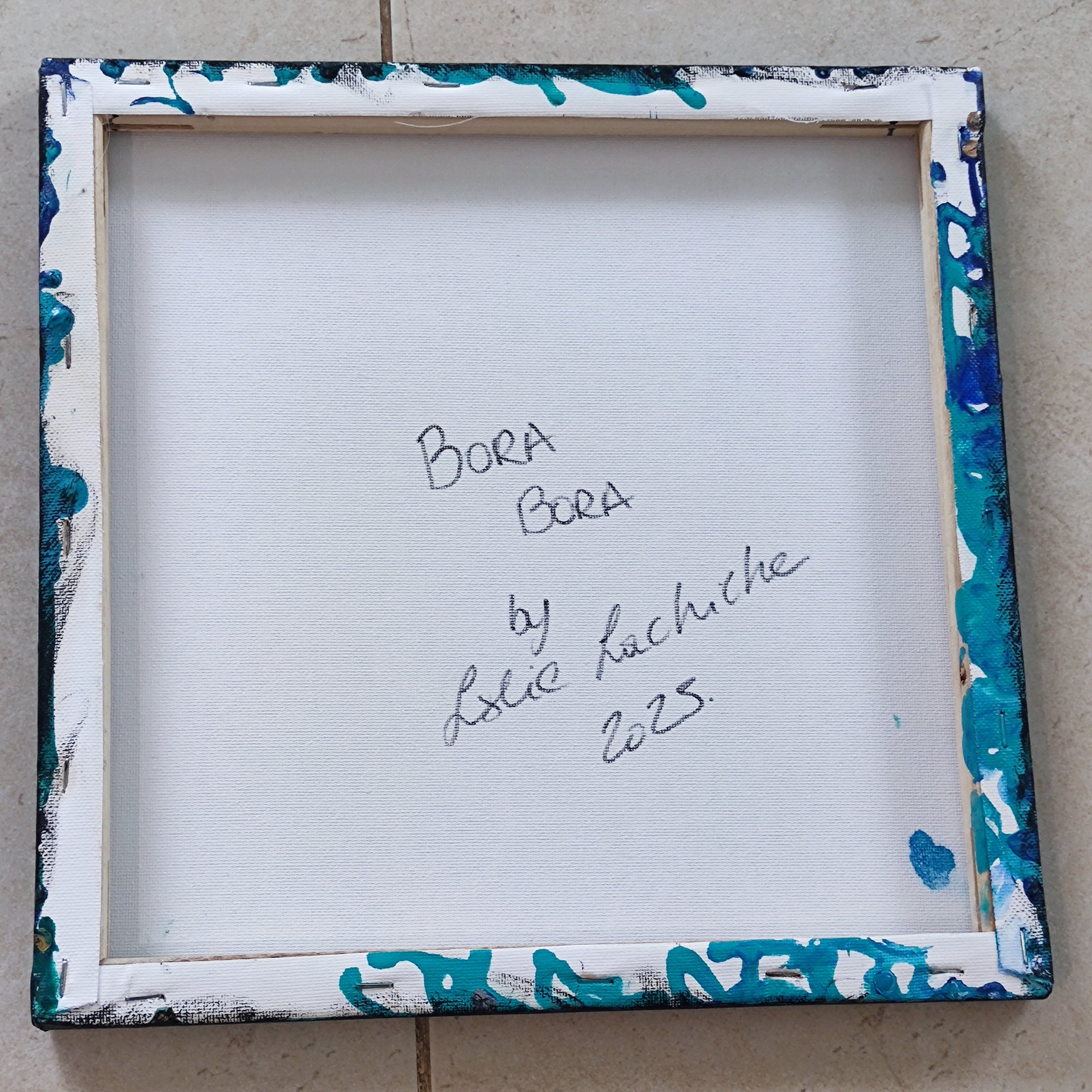 Decorative picture frame with blue and white abstract design on a tiled floor.