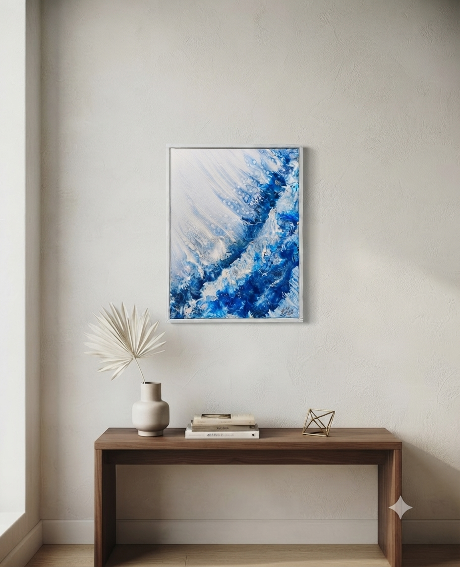 Abstract blue painting on a wall above a wooden console table with decorative items.