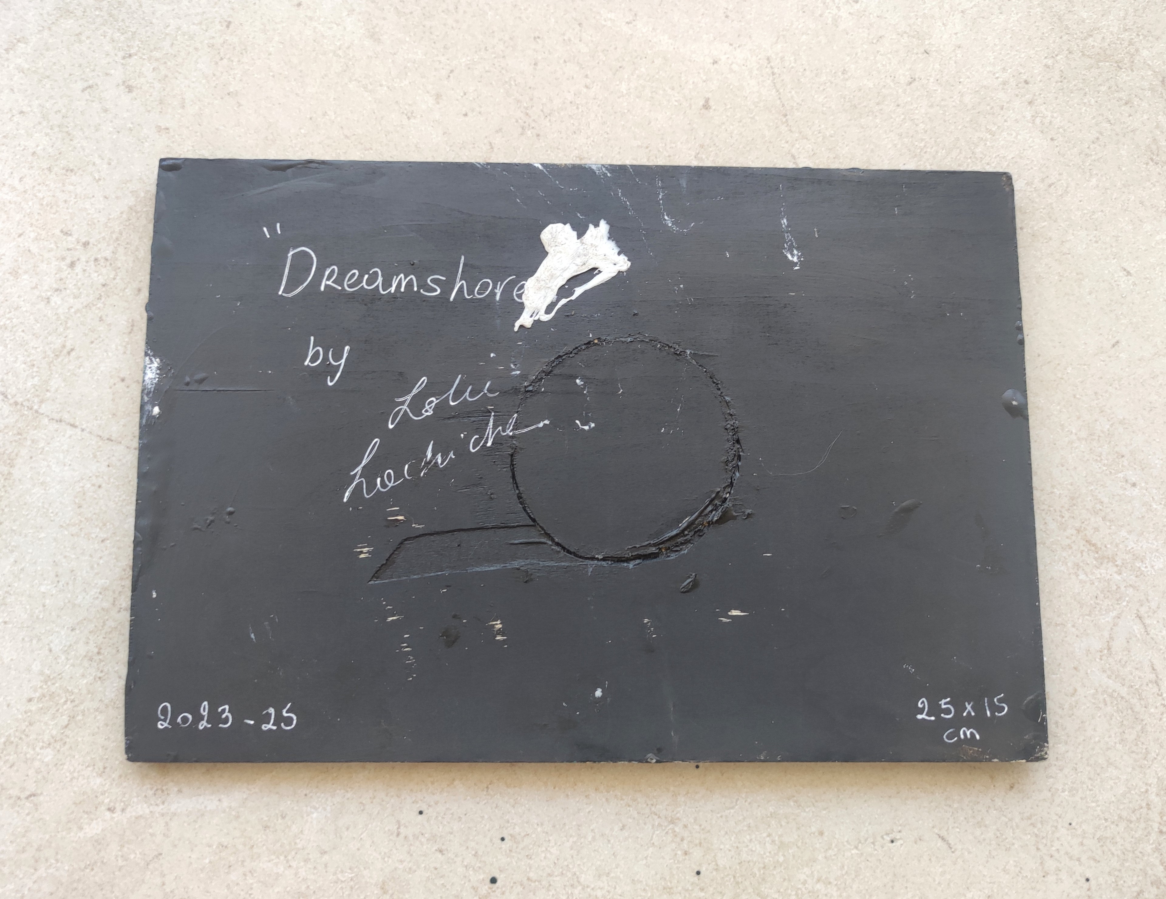 Black slate with 'Dreamshore by Leslie text and measurements on a beige surface