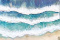 Top-down view of ocean waves crashing onto a sandy beach