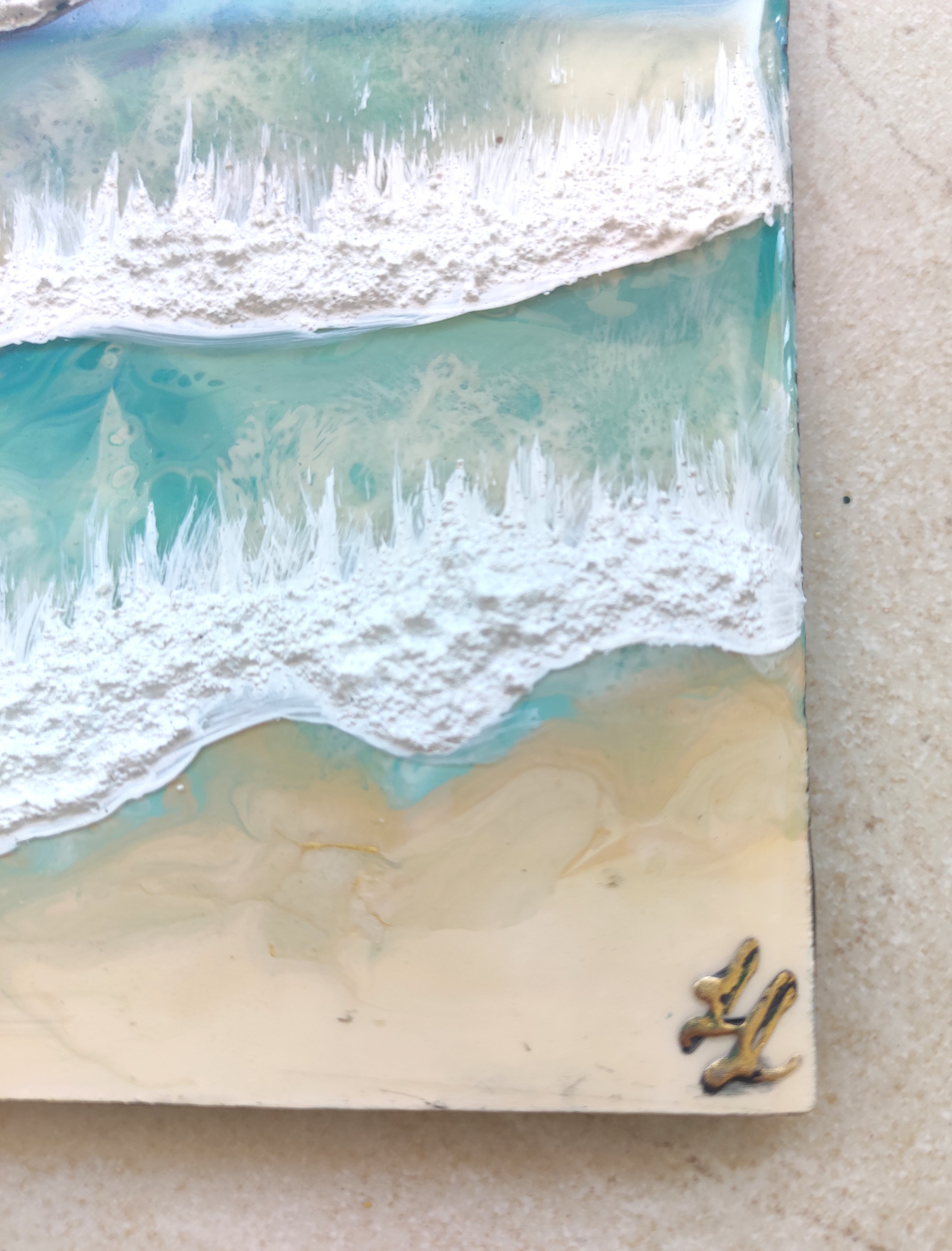 Close-up of a beach scene with waves and sand, featuring a small starfish.
