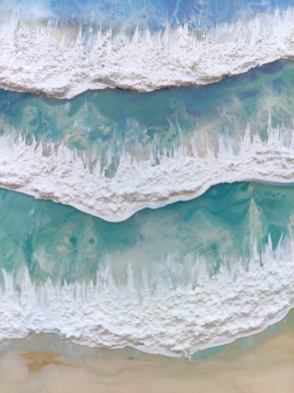 Close-up of ocean waves crashing onto a sandy beach