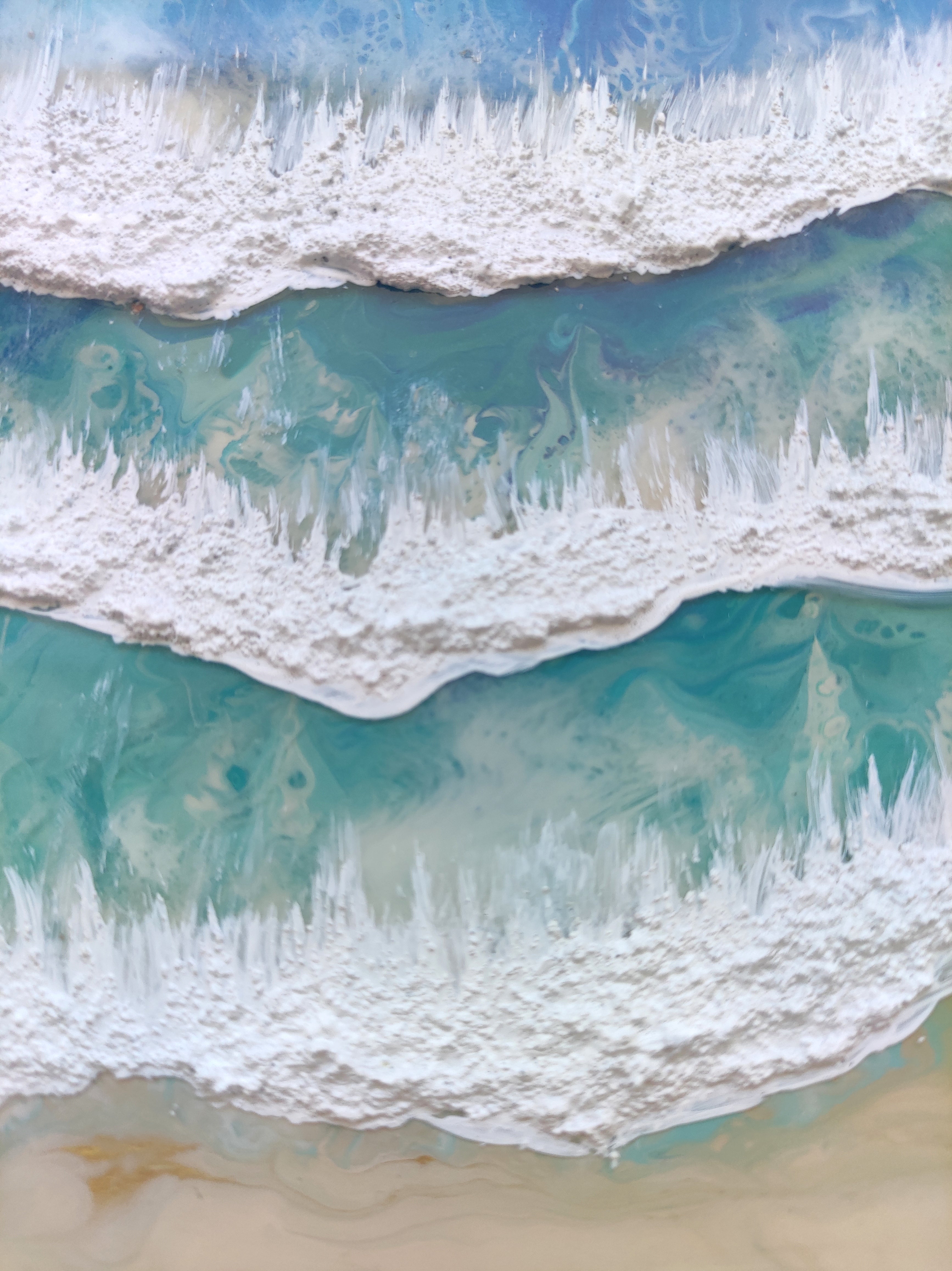Close-up of ocean waves crashing onto a sandy beach
