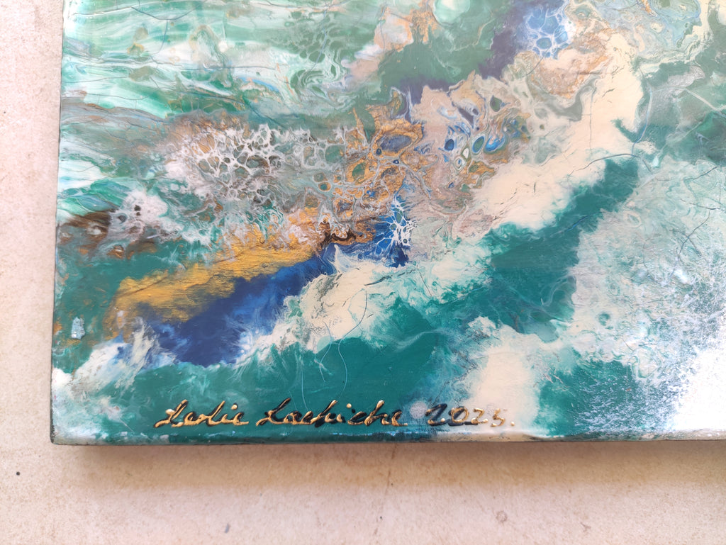 Marbled artwork with a signature on a beige surface