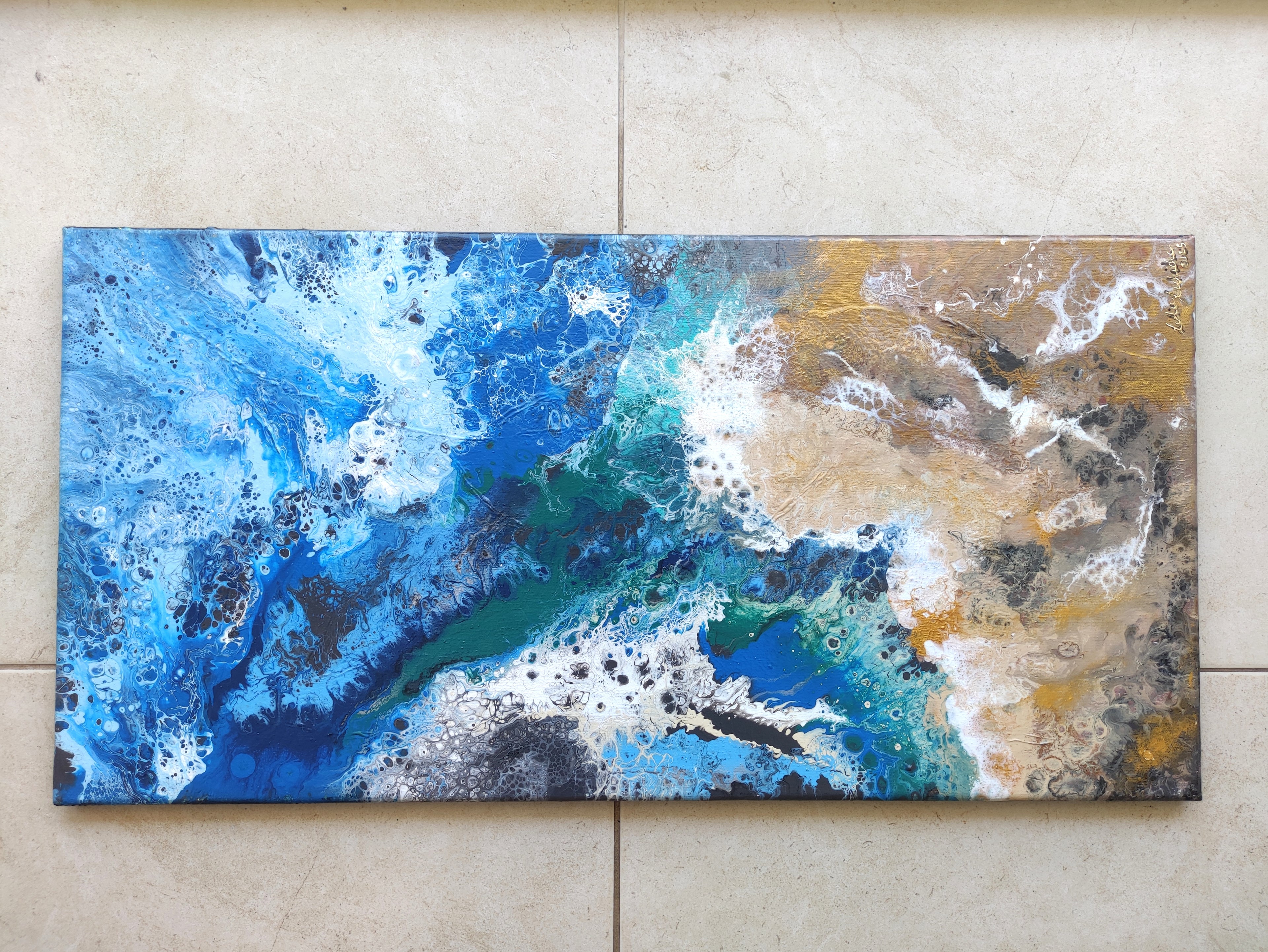 Abstract painting with blue, gold, and white on a beige wall