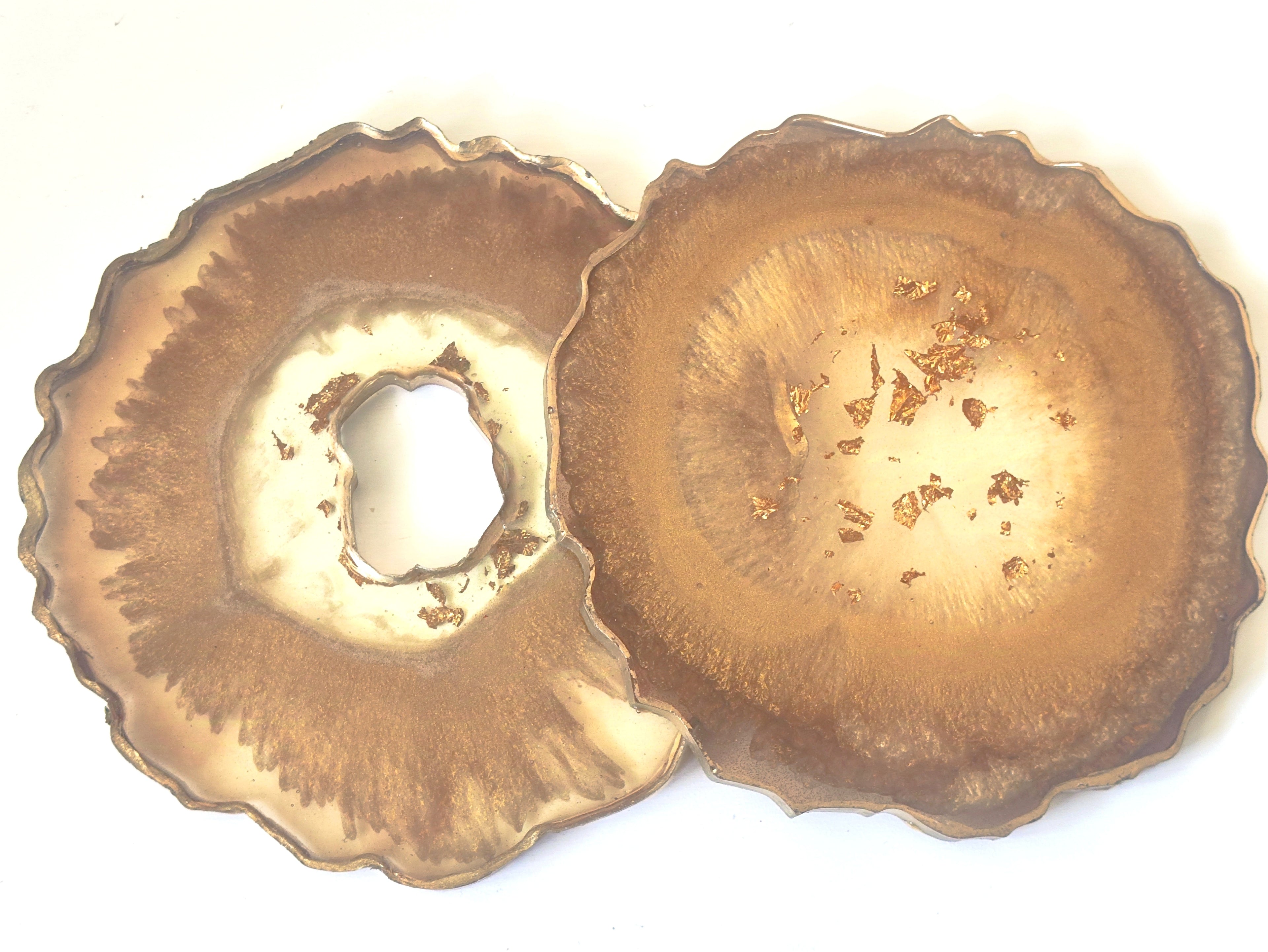 Two brownish-orange petal-shaped geode coasters on a white background