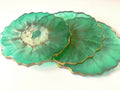 Green petal-shaped coasters on a white background