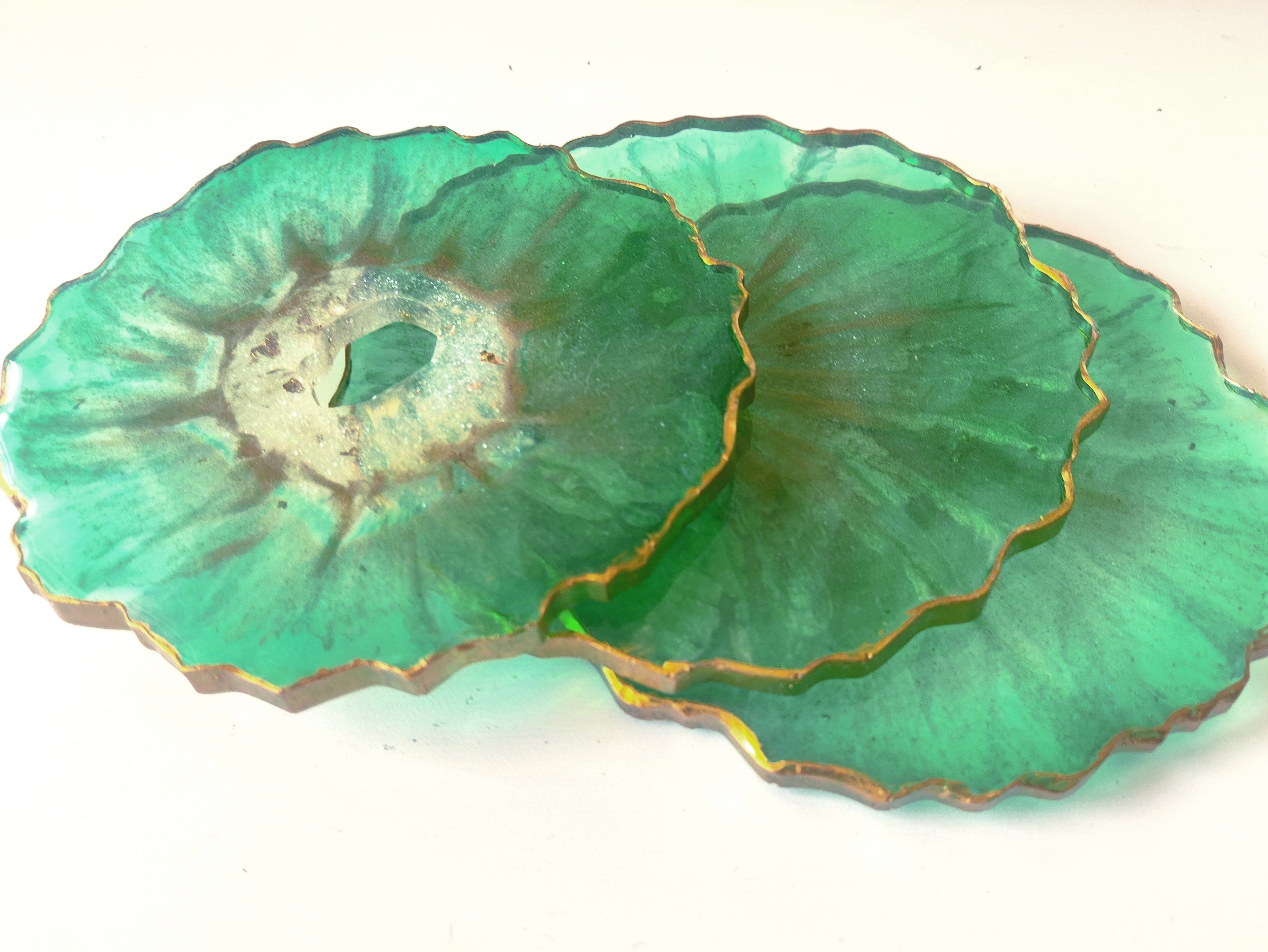 Green petal-shaped coasters on a white background