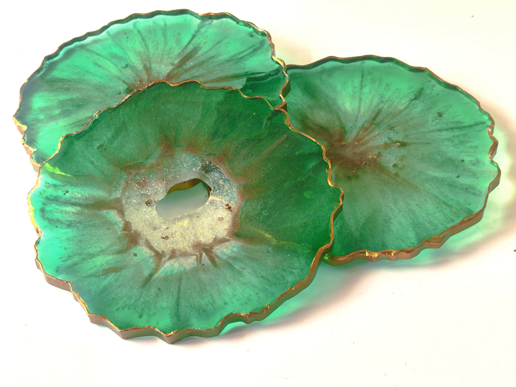Two green agate slices with gold edges on a white background