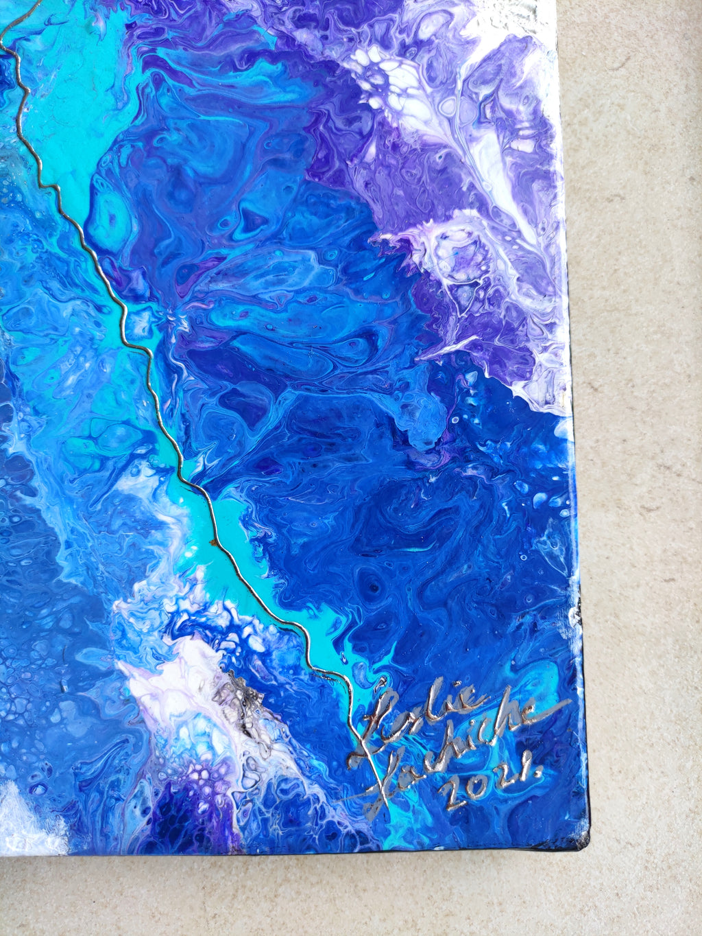 Artistic depiction of blue and purple abstract design with a signature and year on a beige background