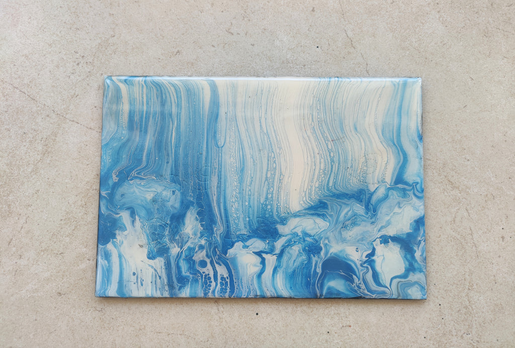 Blue and white abstract painting on a textured beige surface