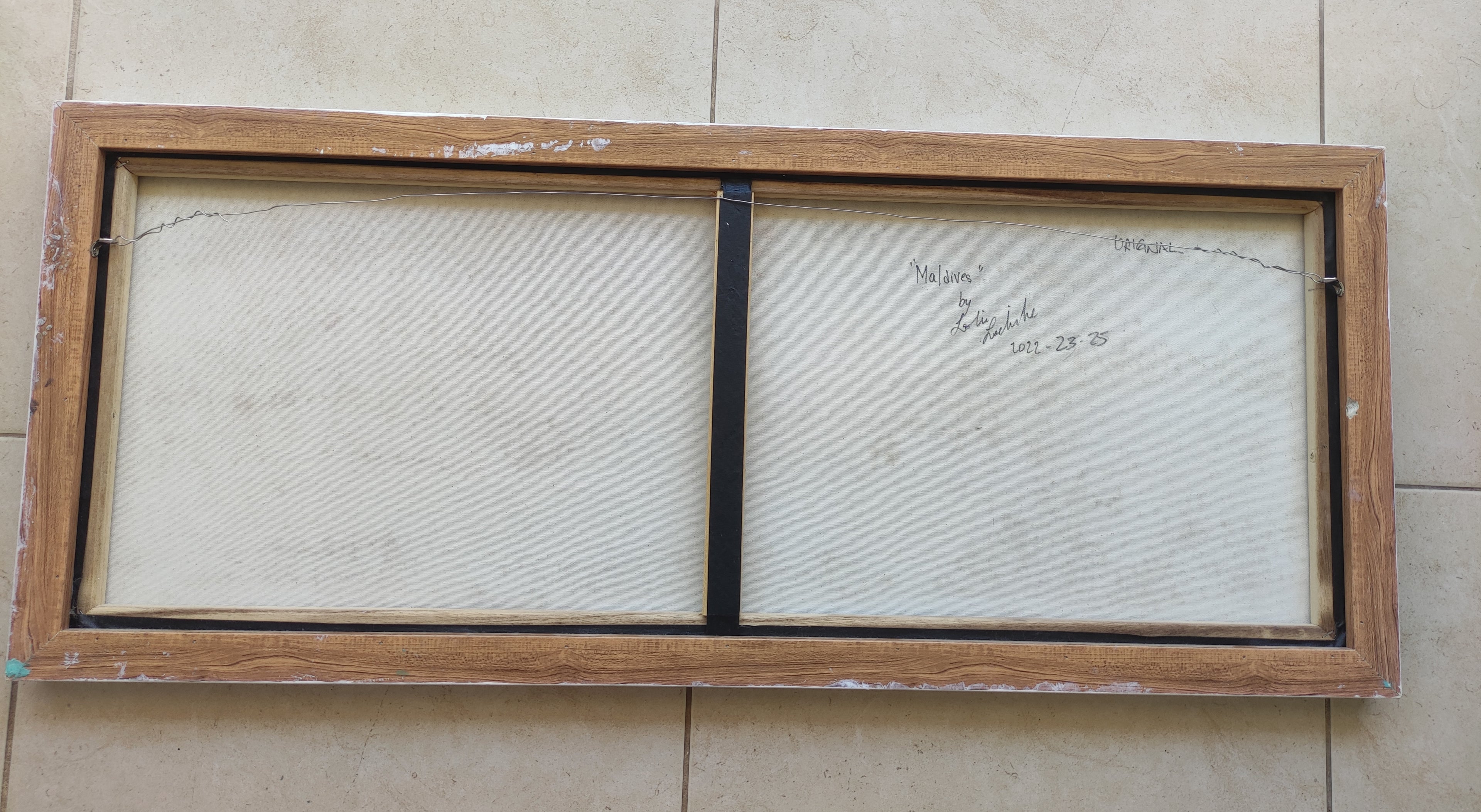 Wooden picture frame with glass on a tiled floor