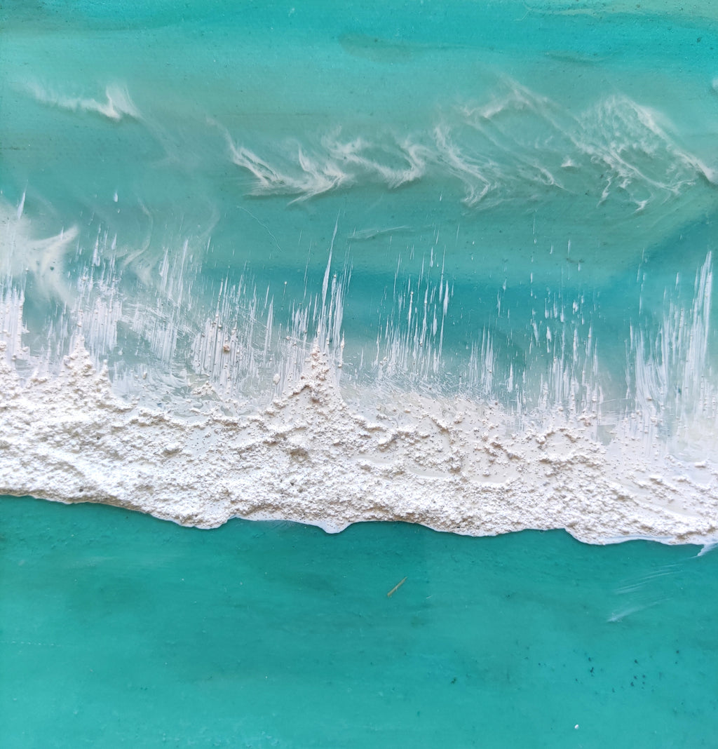 Artistic depiction of a beach scene with turquoise water and sand, featuring a brand name.
