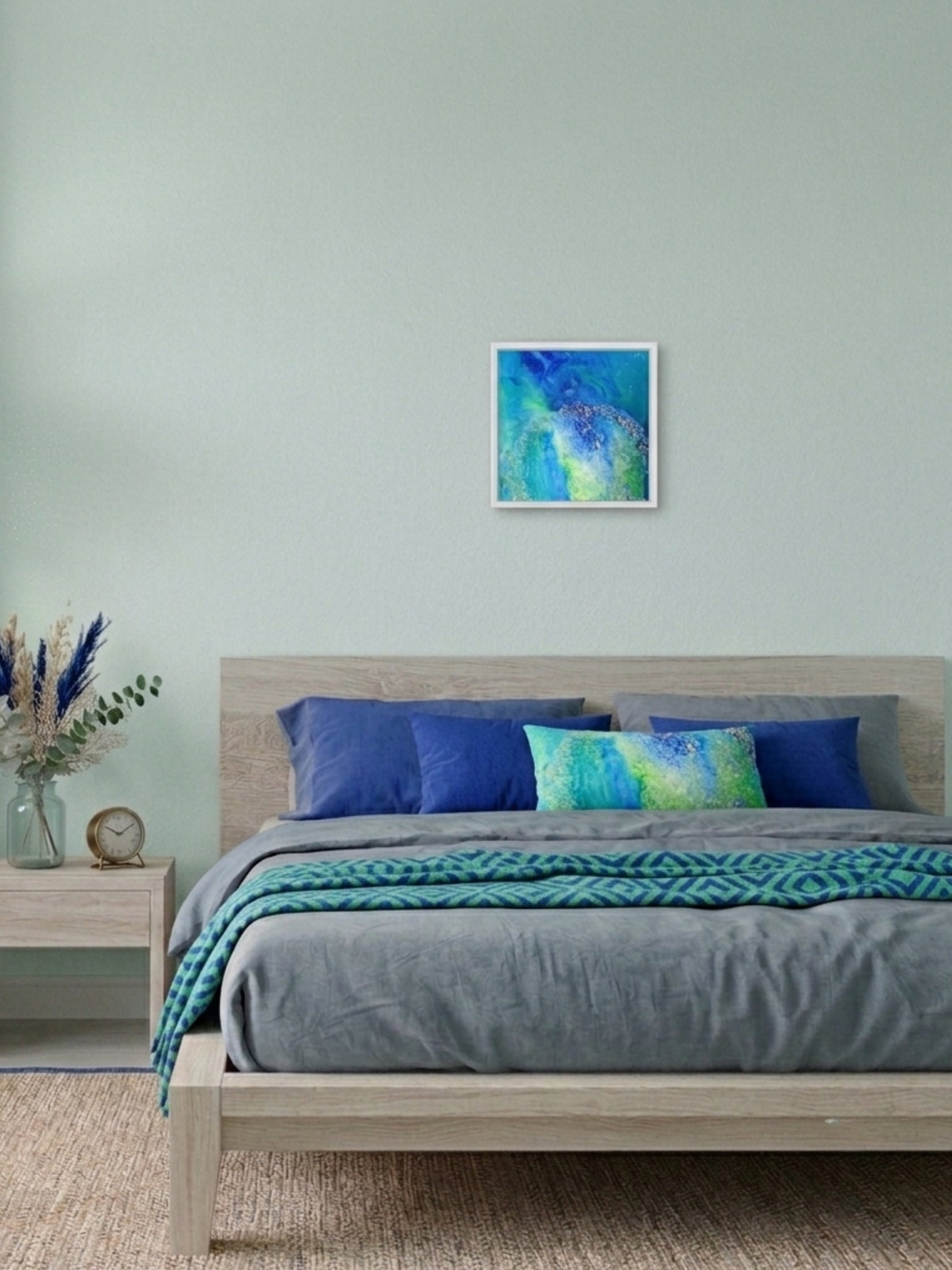 Bedroom with a bed featuring blue and green bedding, a nightstand, and a painting on the wall.