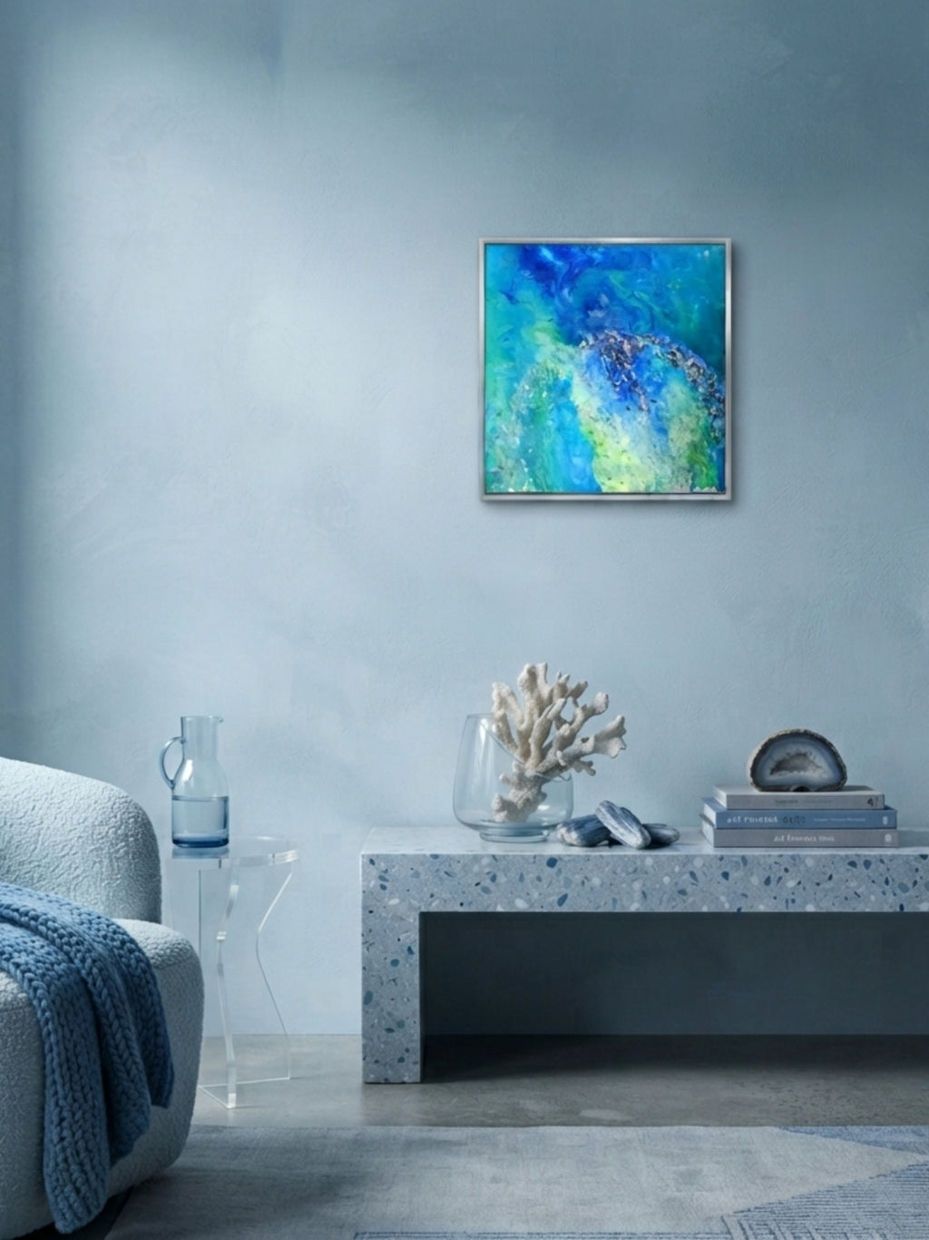 Living room with a blue abstract painting on the wall, gray sofa, and decorative items on a coffee table.