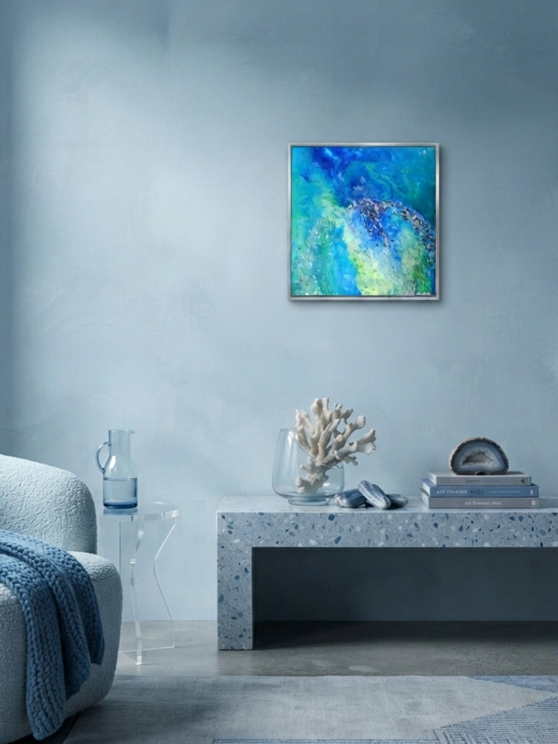 Living room with a blue abstract painting on the wall, gray sofa, and decorative items on a coffee table.
