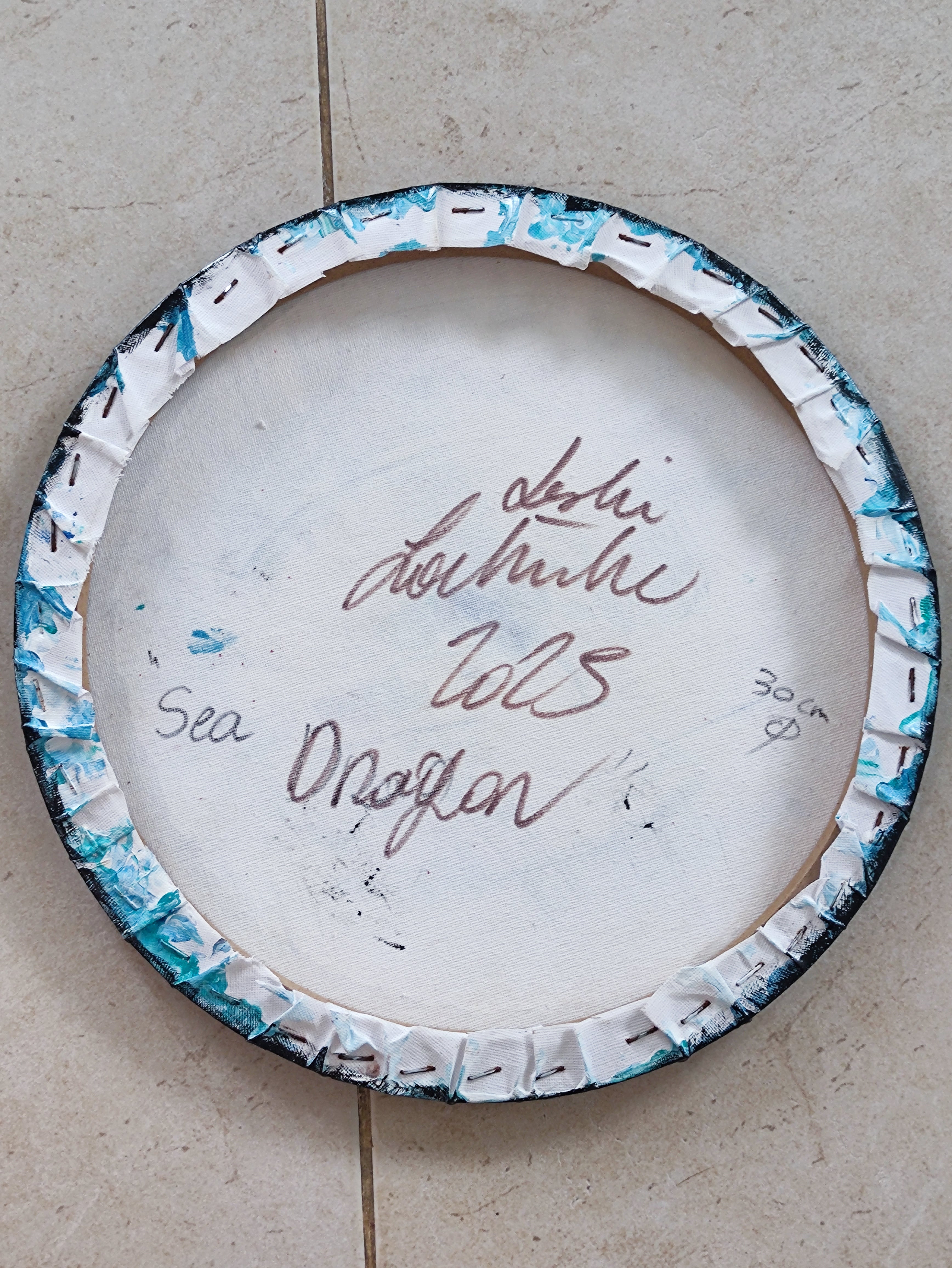 Back of painting with decorative rim on a beige surface