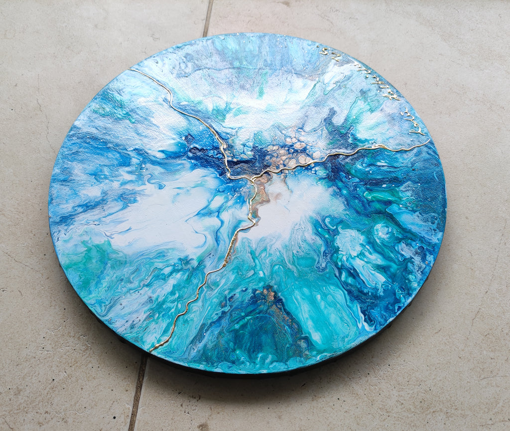 Round blue and green marbled surface on a concrete floor