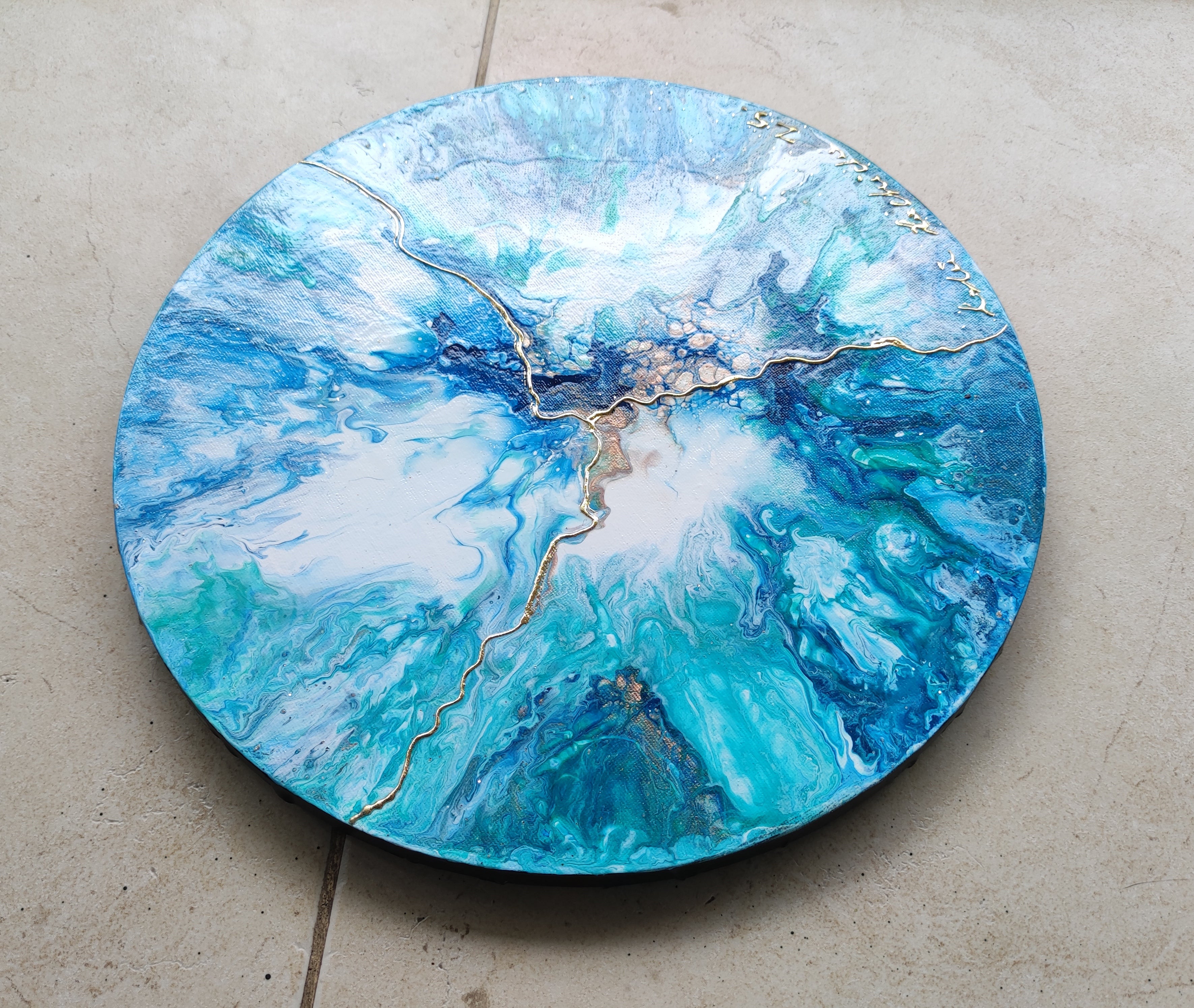 Round blue and green marbled surface on a concrete floor