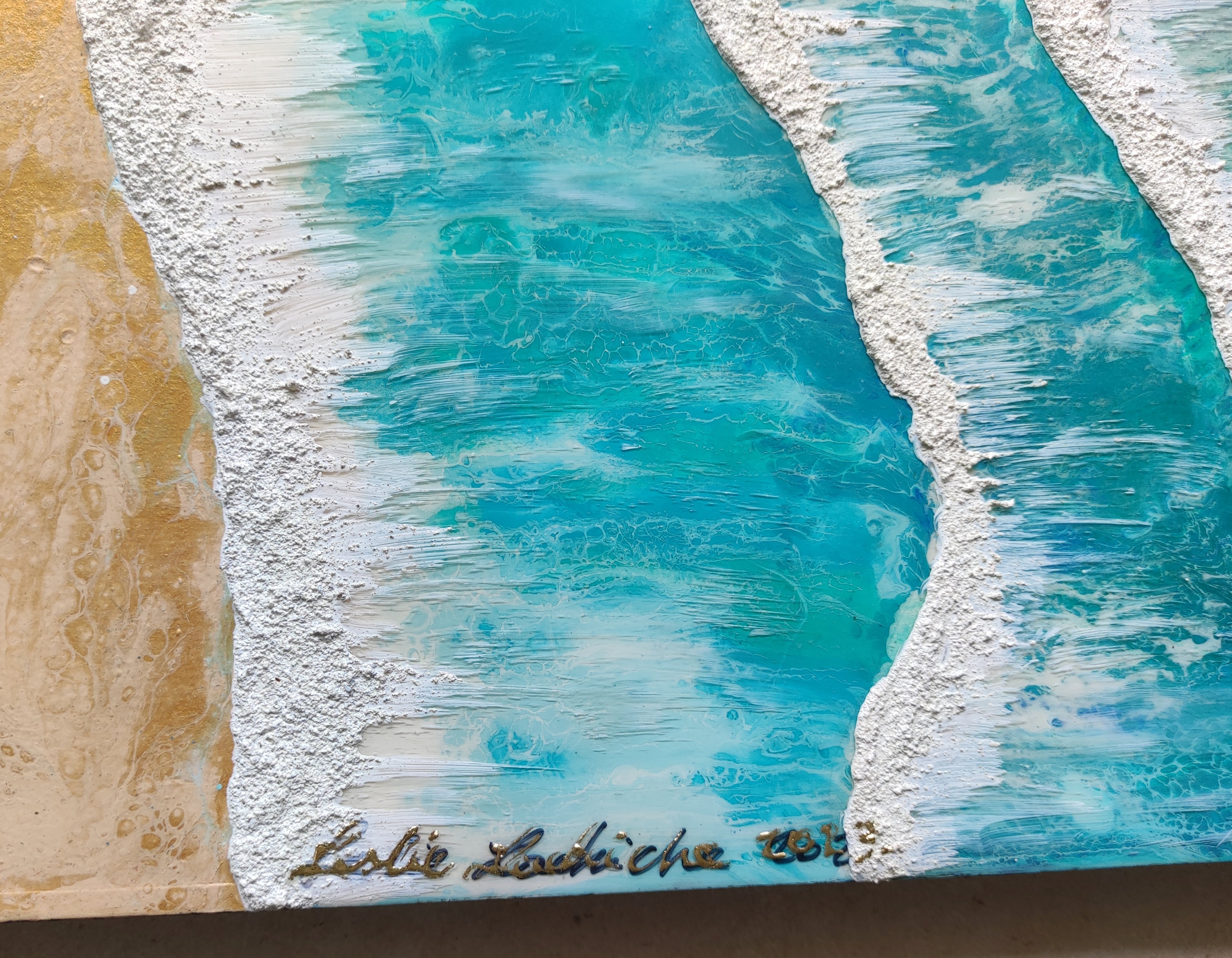 Close-up of a textured surface with blue and white patterns, featuring the artist's signature.