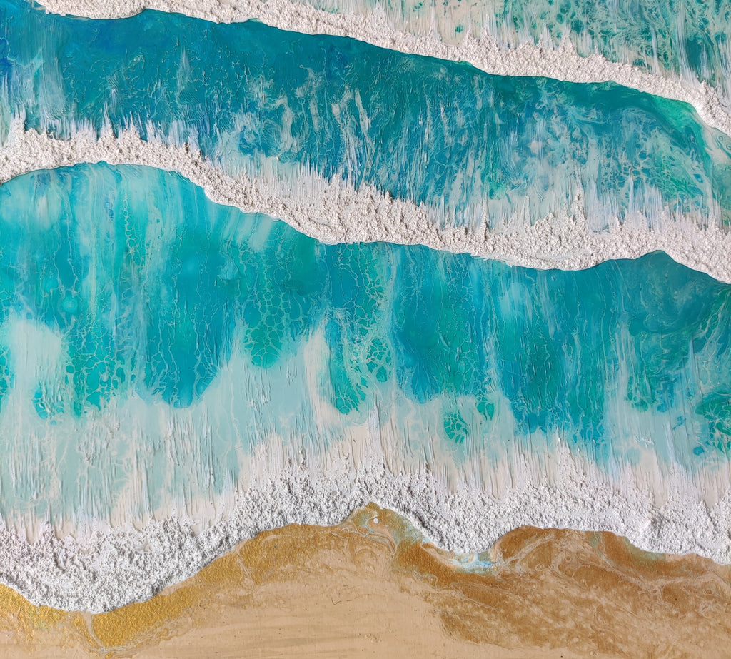 Top-down view of waves crashing onto a sandy beach