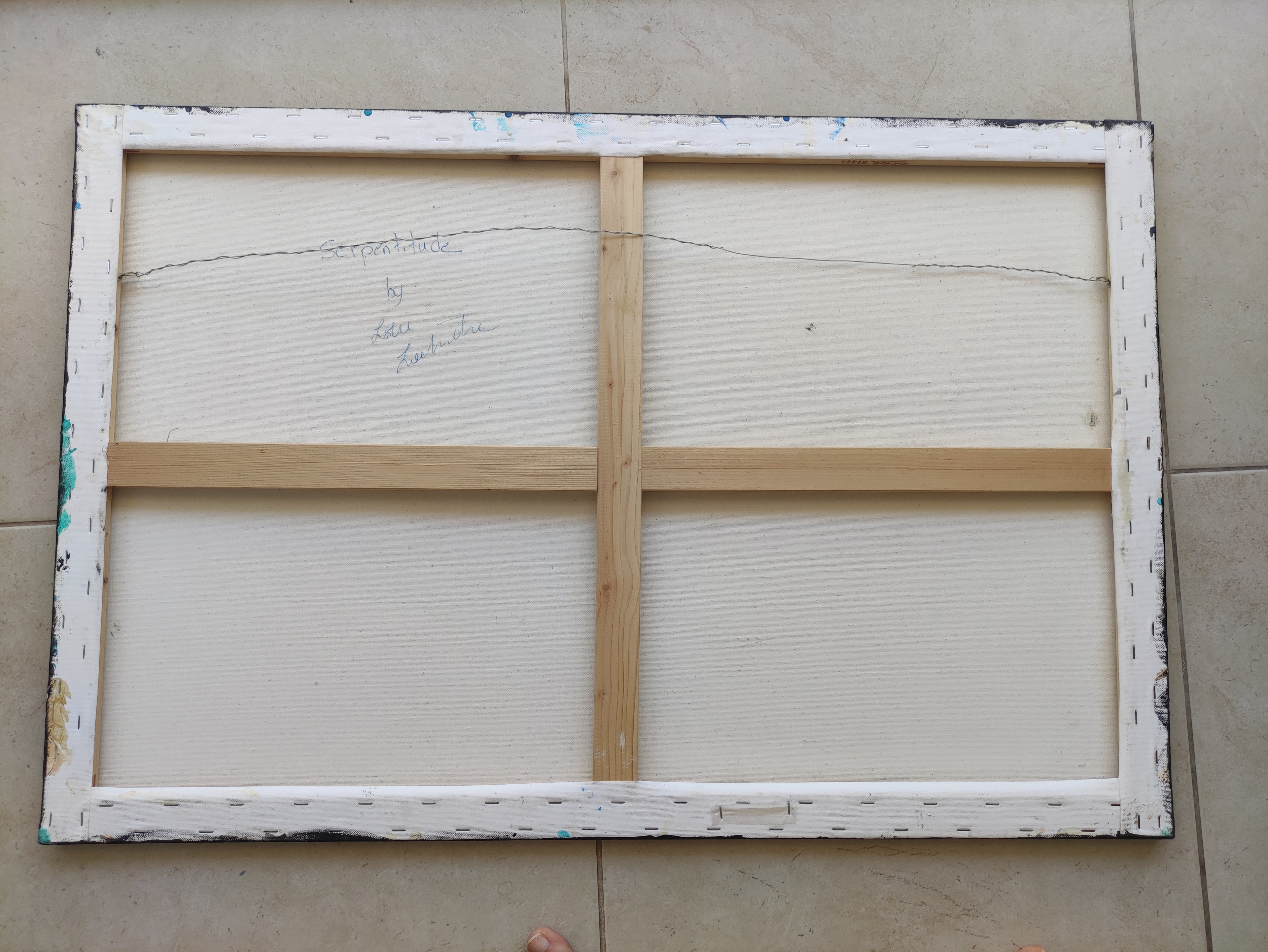 Wooden picture frame with white mat on a tiled floor