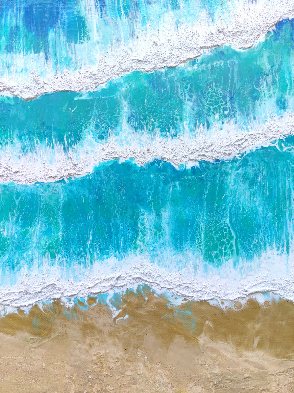 Close-up of blue ocean waves crashing onto a sandy beach