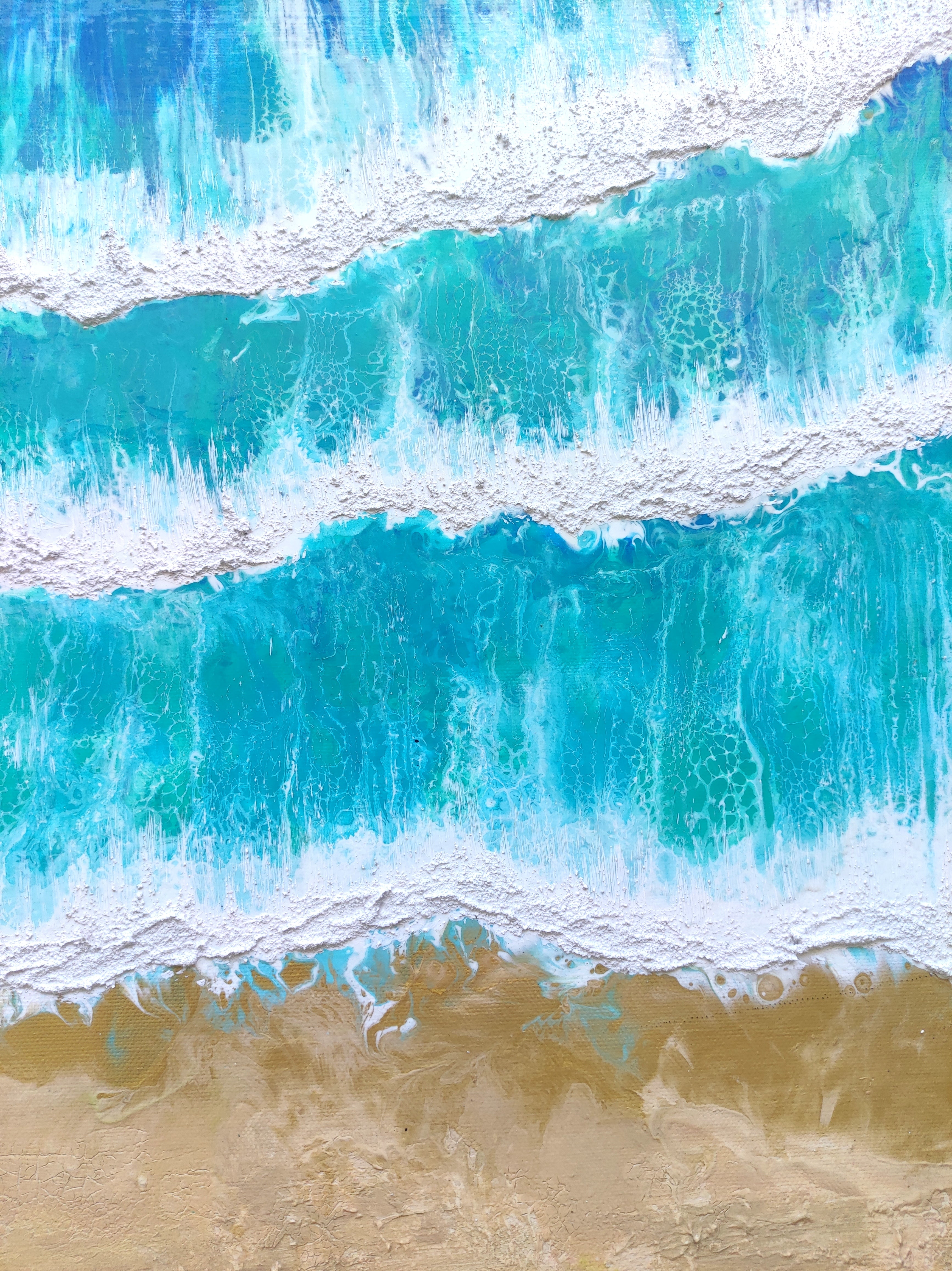 Close-up of blue ocean waves crashing onto a sandy beach