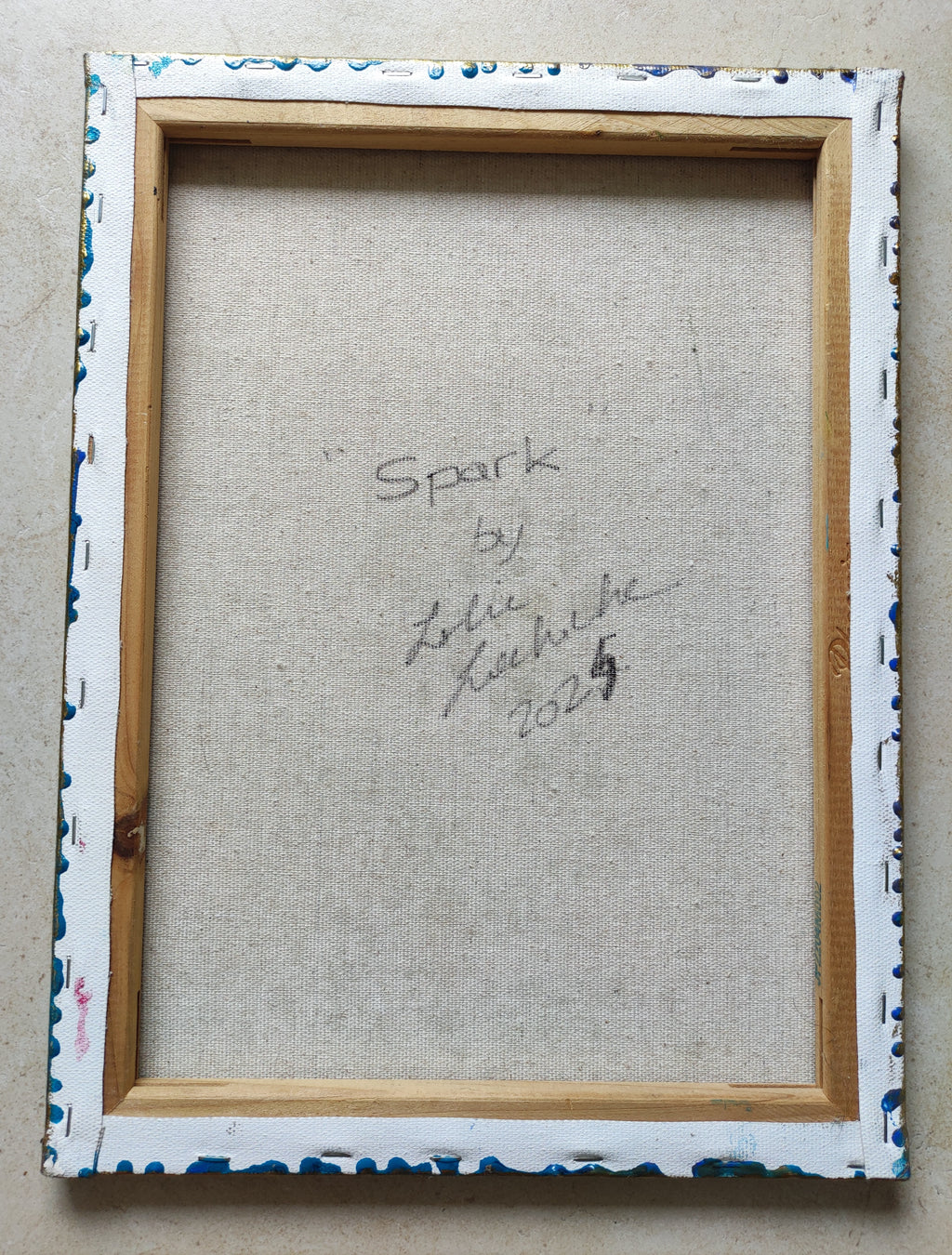 Framed artwork with signature on a textured surface