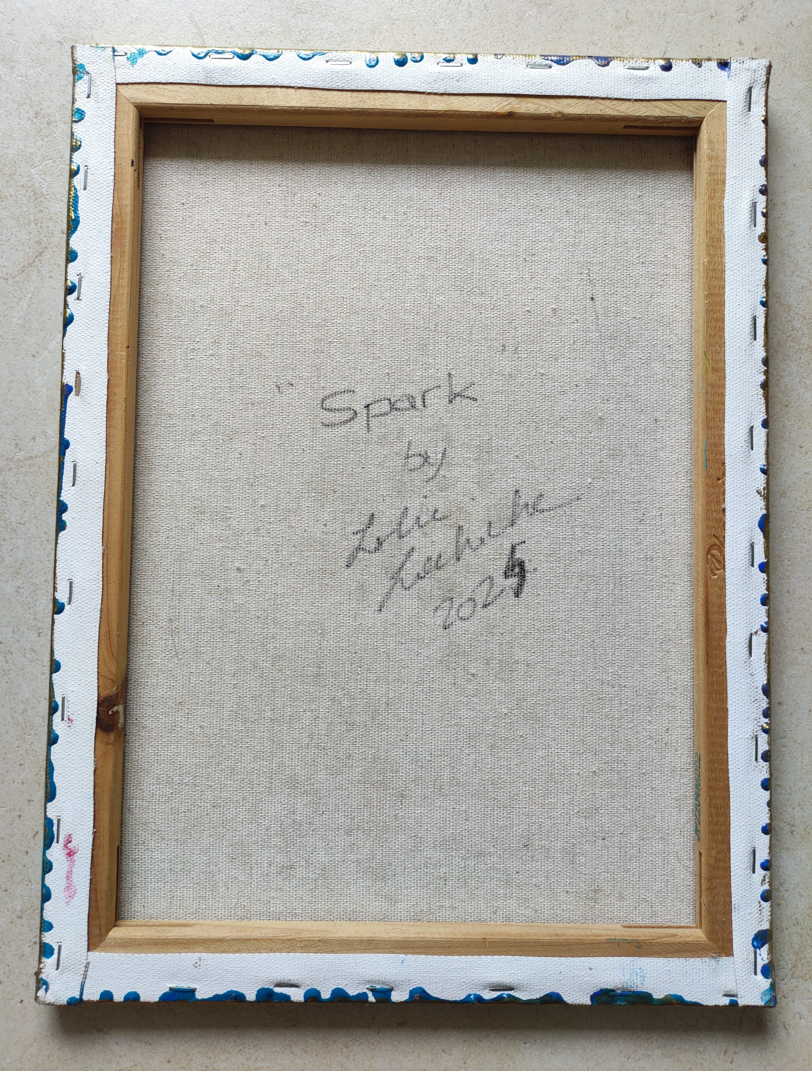 Framed artwork with signature on a textured surface