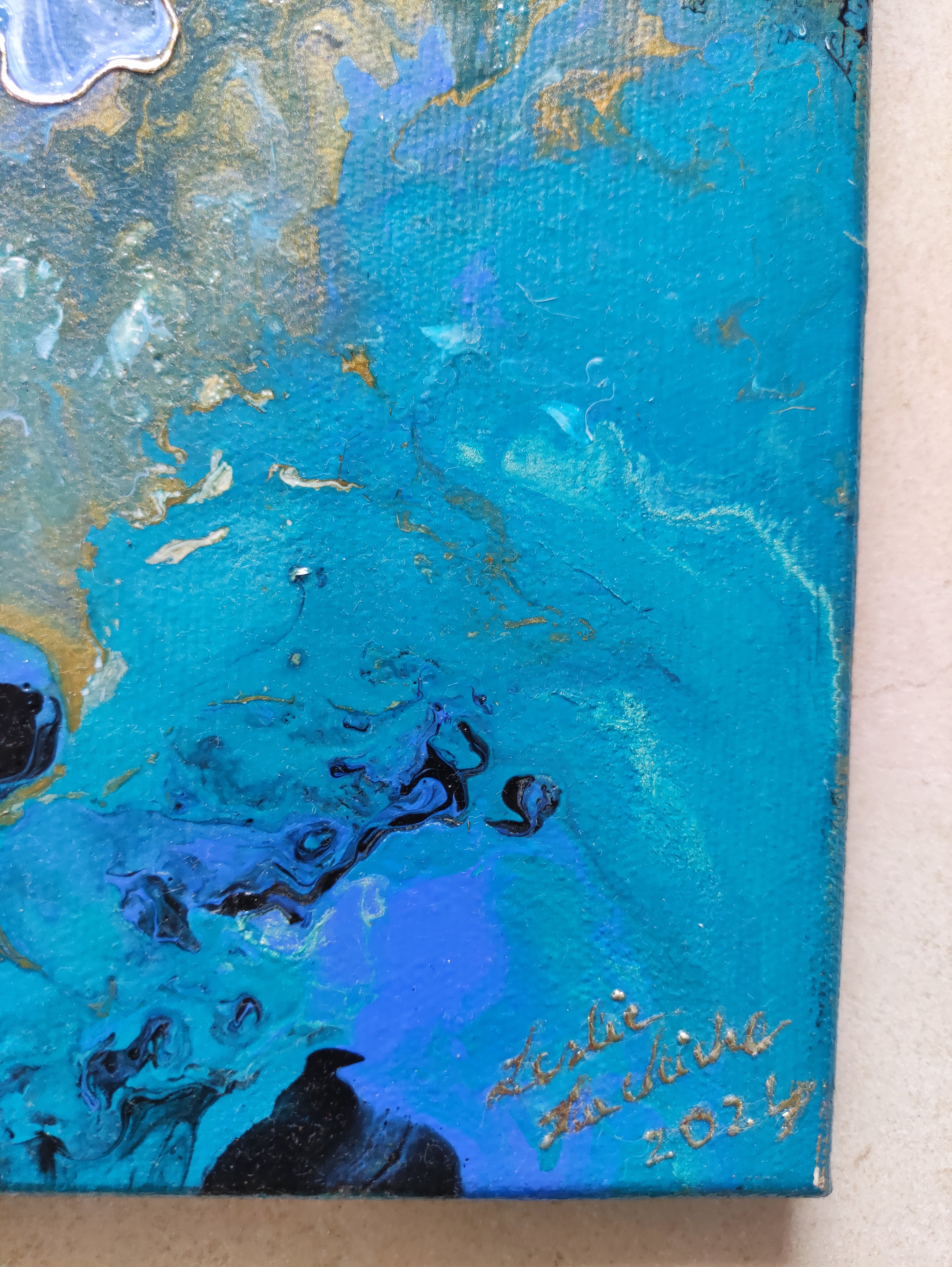 Abstract painting with blue and gold tones on a textured surface