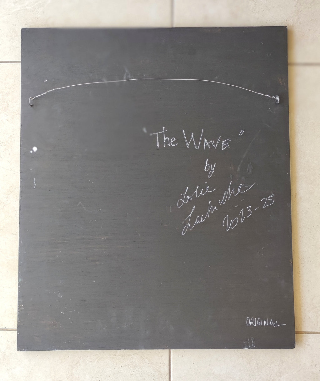 Blackboard with 'The Wave' by Lole Lole signature and date on a tiled floor.
