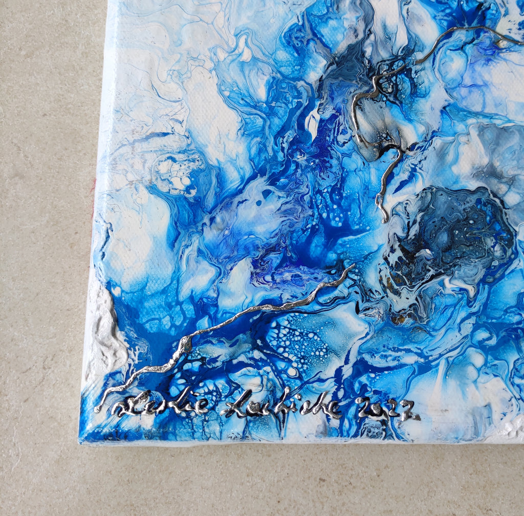 Abstract blue and white painting with a signature on a beige background
