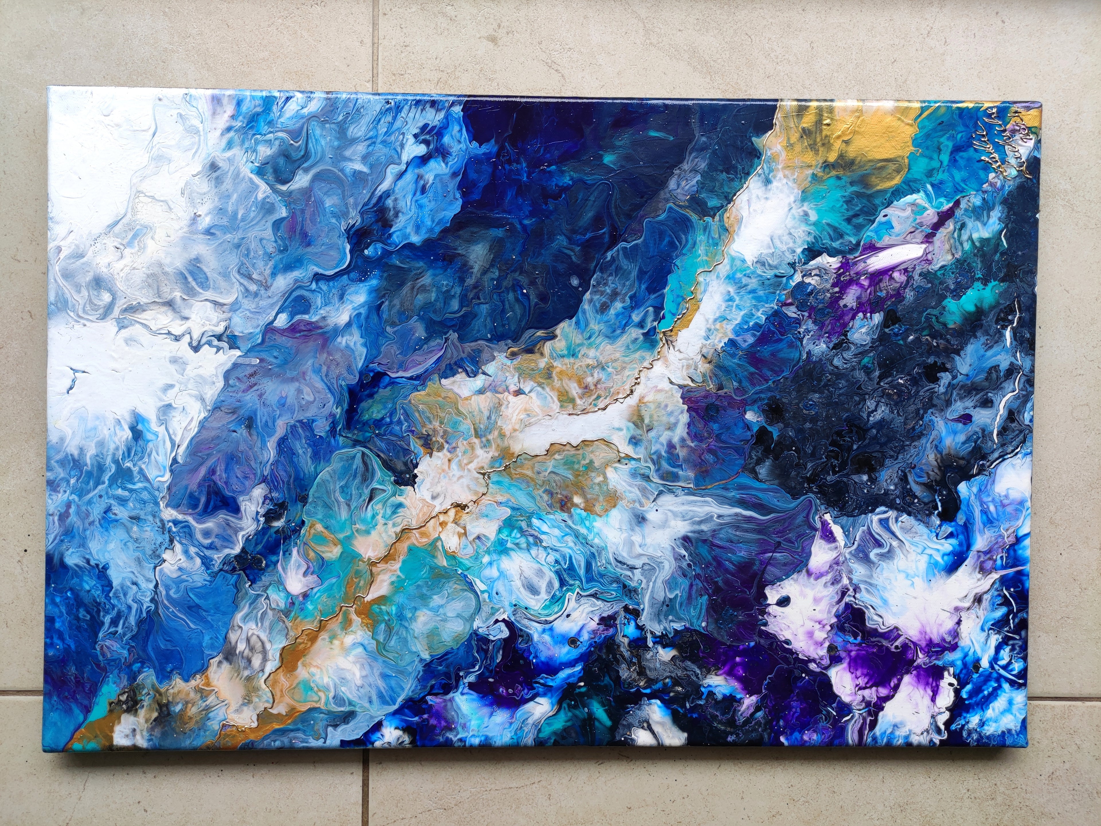 Abstract painting with blue, purple, and gold colors on a textured wall.