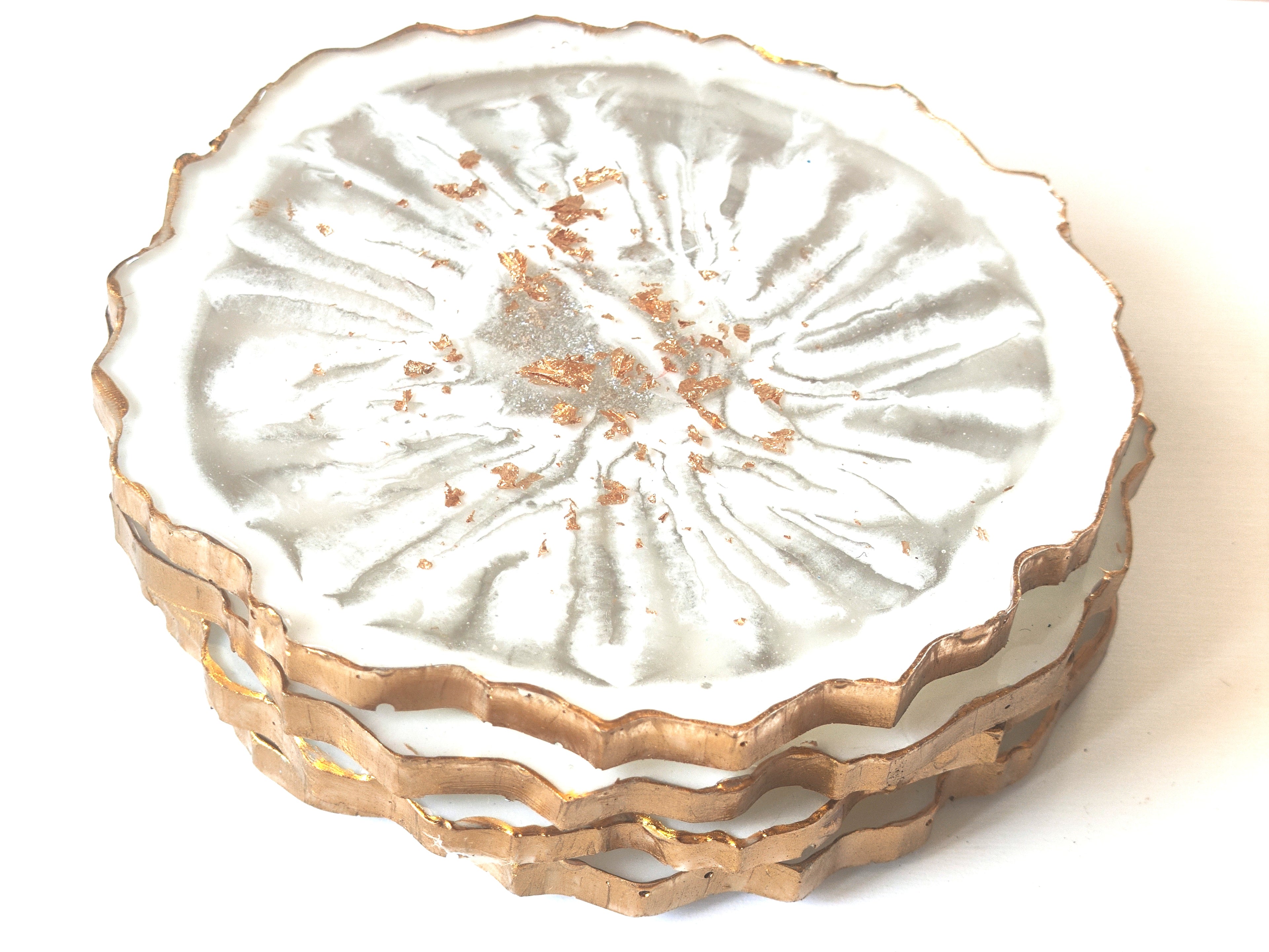 Decorative ceramic coasters with gold rim on a white background