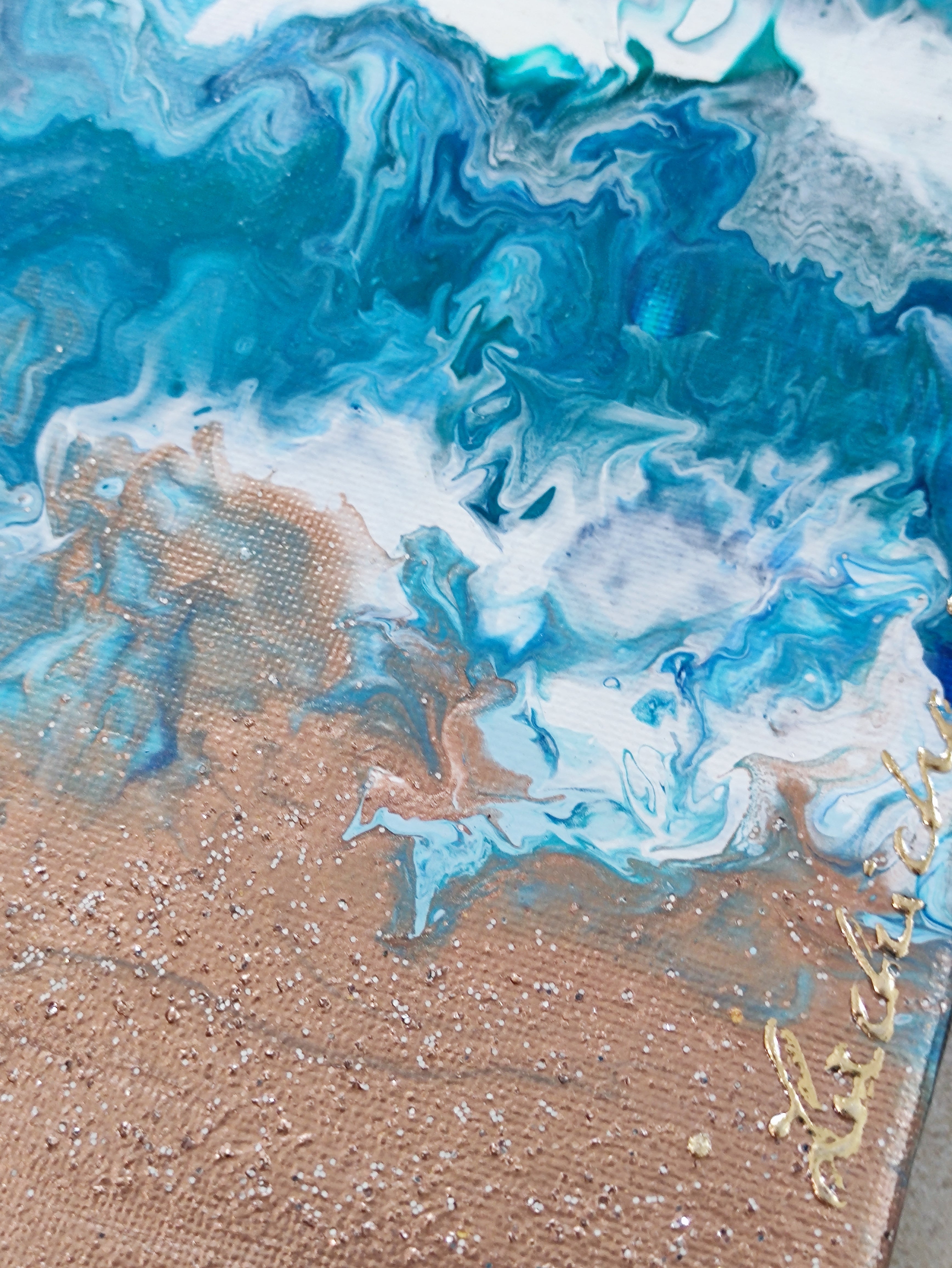 Abstract art piece with blue, white, and gold colors on a textured surface.